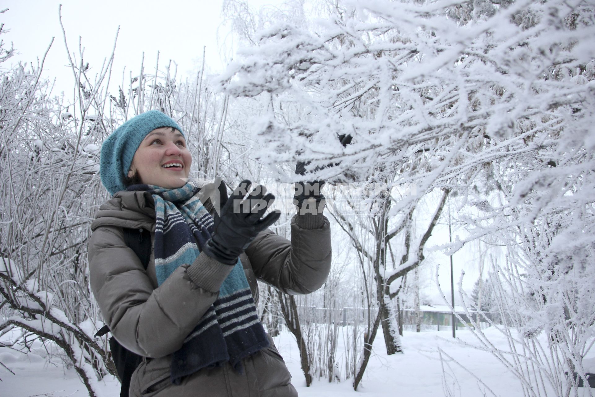 Девушка любуется заснеженными деревьями.