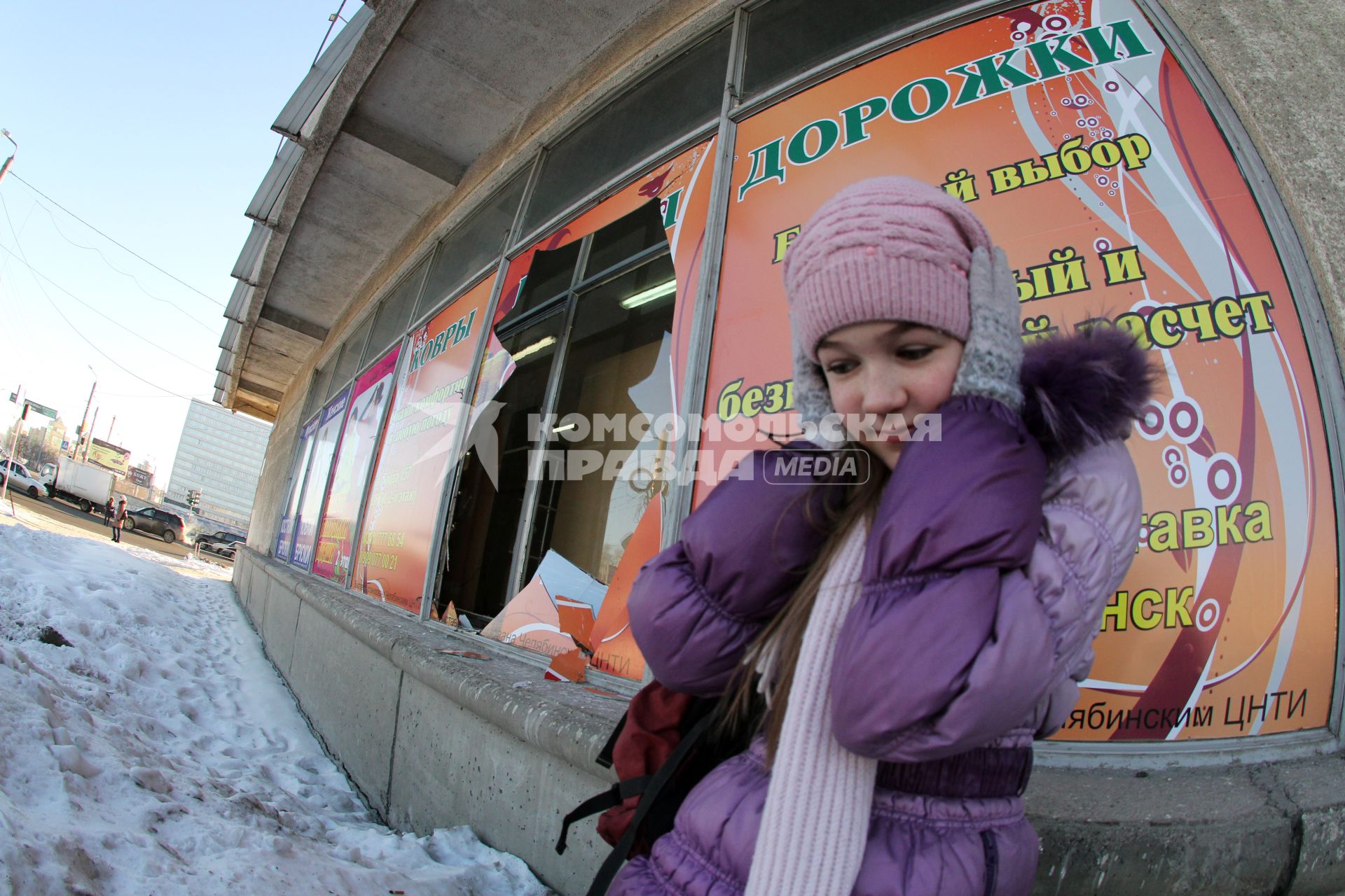 Последствия падения метеорита. Девочка закрывает руками уши рядом с разбитой витриной магазина в Челябинске.