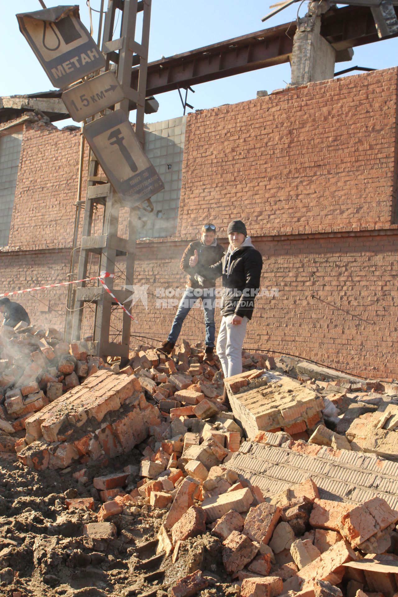 Последствия падения метеорита. Мужчины на развалинах разрушенного фасада завода в Челябинске.