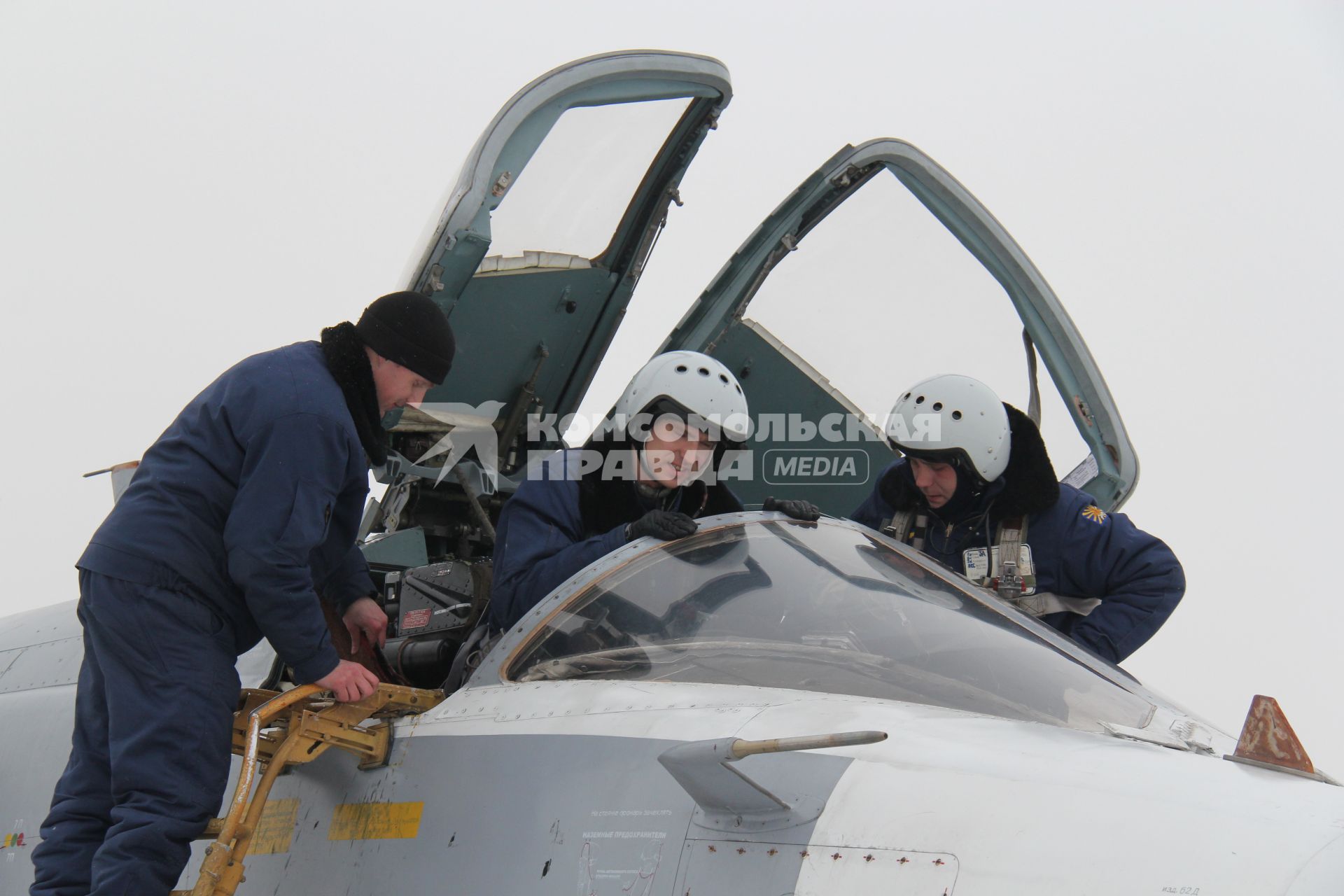 Пилоты садятся в кабину фронтового бомбардировщика  СУ-24М, рядом стоит техник.
