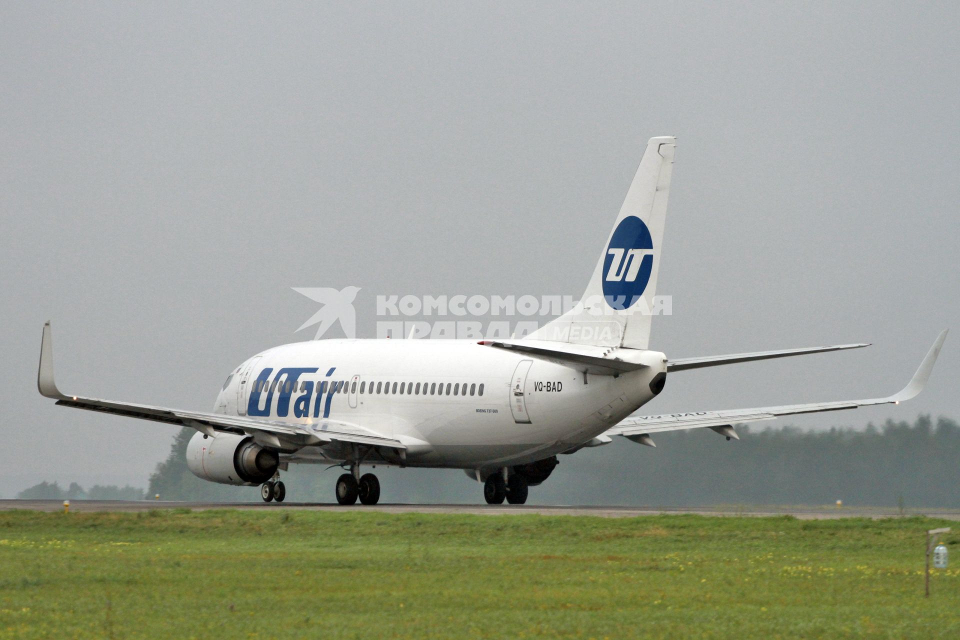 Пассажирский самолет Boeing 737-500 авиакомпания `UTair` на взлетно-посадочной полосе.