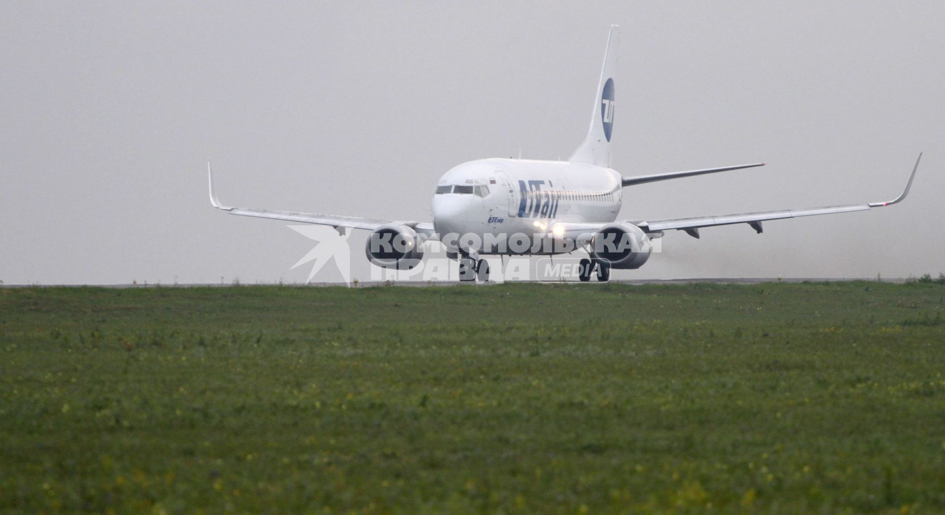 Пассажирский самолет Boeing 737-500 авиакомпания `UTair` на взлетно-посадочной полосе.