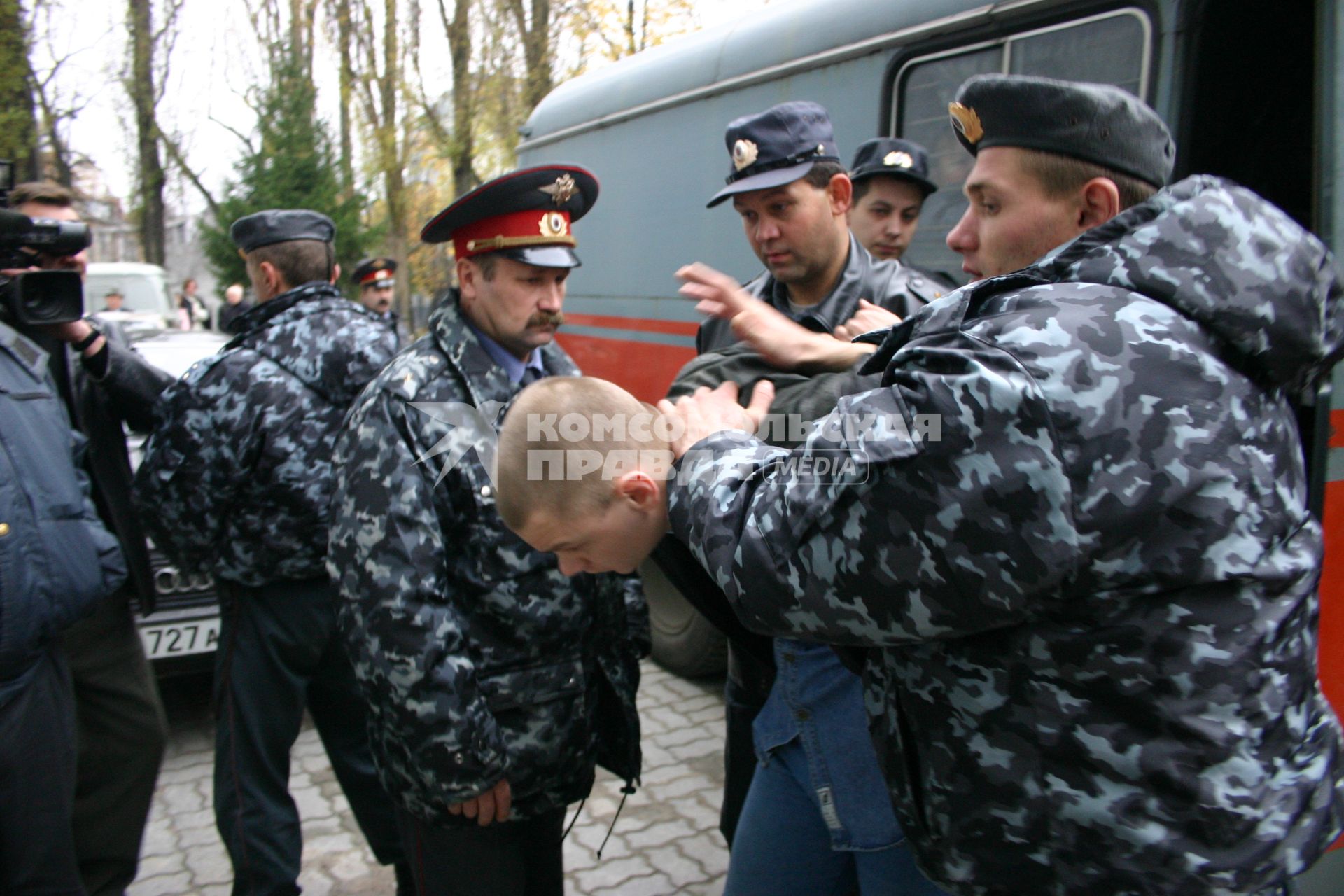 Полицейские полицейские выводят нарушителя из здания суда