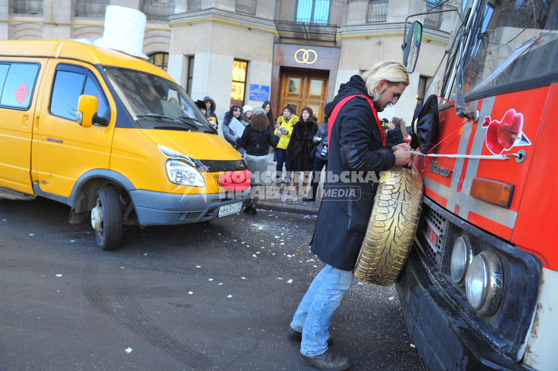 Креативная свадьба 12.12.12. На снимке: молодой человек с автомобильным колесом в руках.