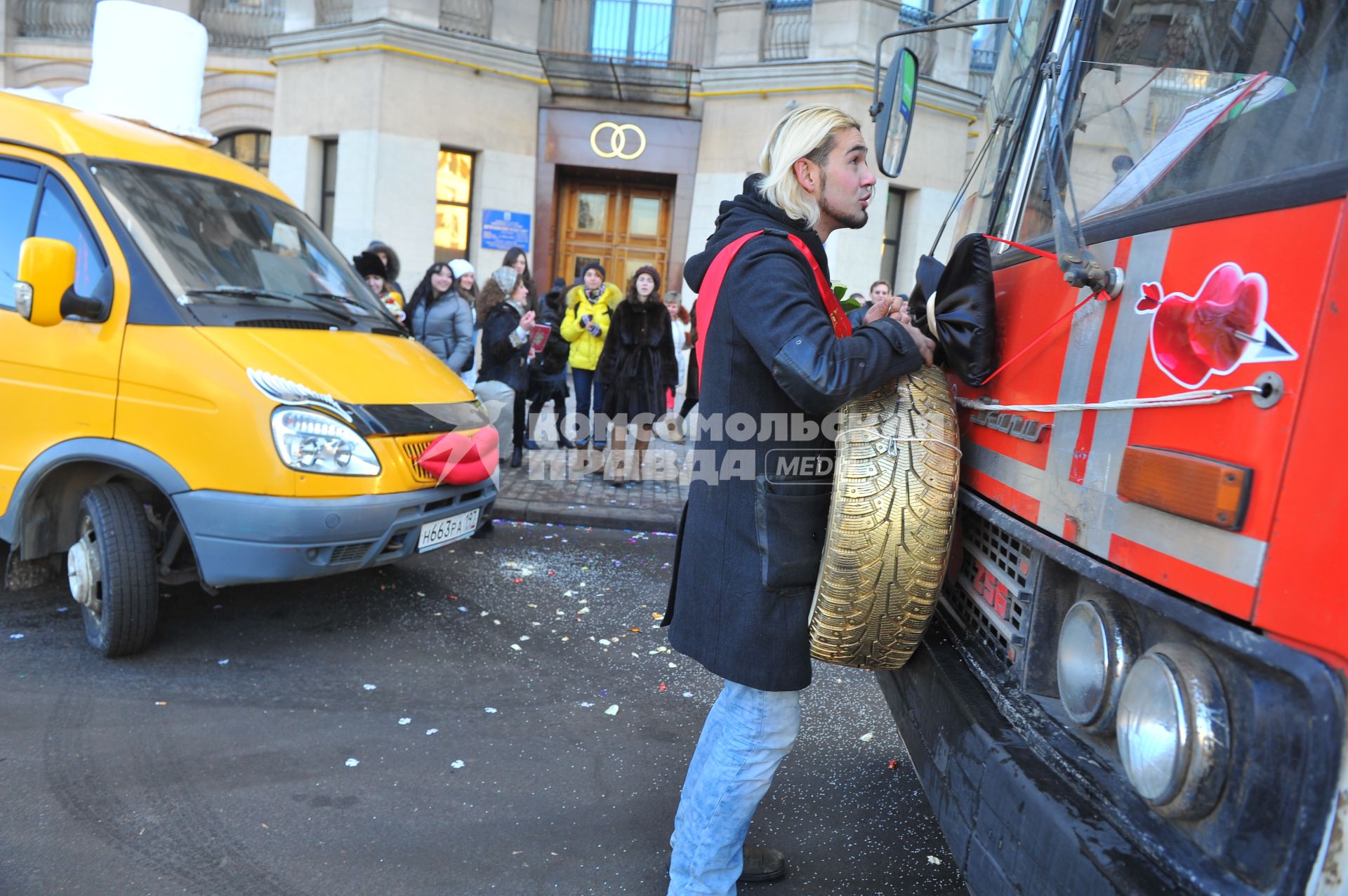 Креативная свадьба 12.12.12. На снимке: молодой человек с автомобильным колесом в руках.