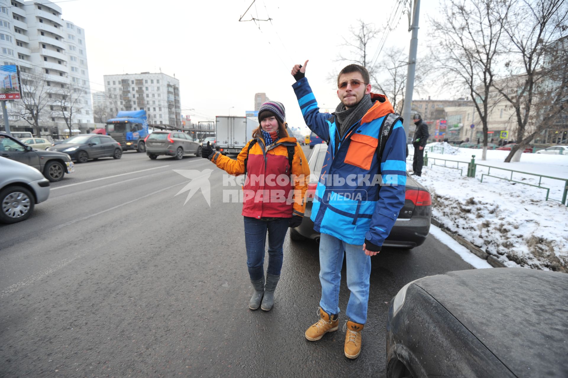 Путешествие автостопом. На снимке: молодые люди голосуют на шоссе.