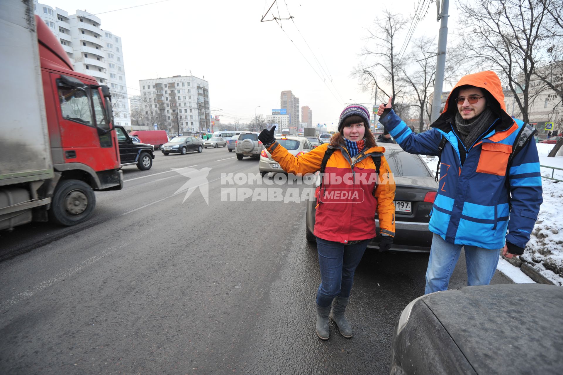 Путешествие автостопом. На снимке: молодые люди голосуют на шоссе.