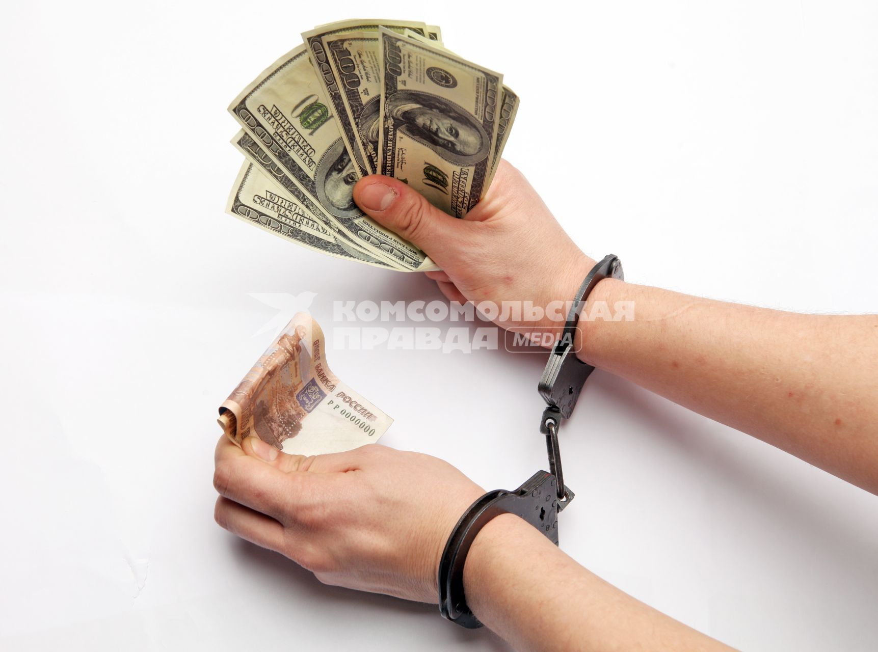 Руки с деньгами в наручниках.