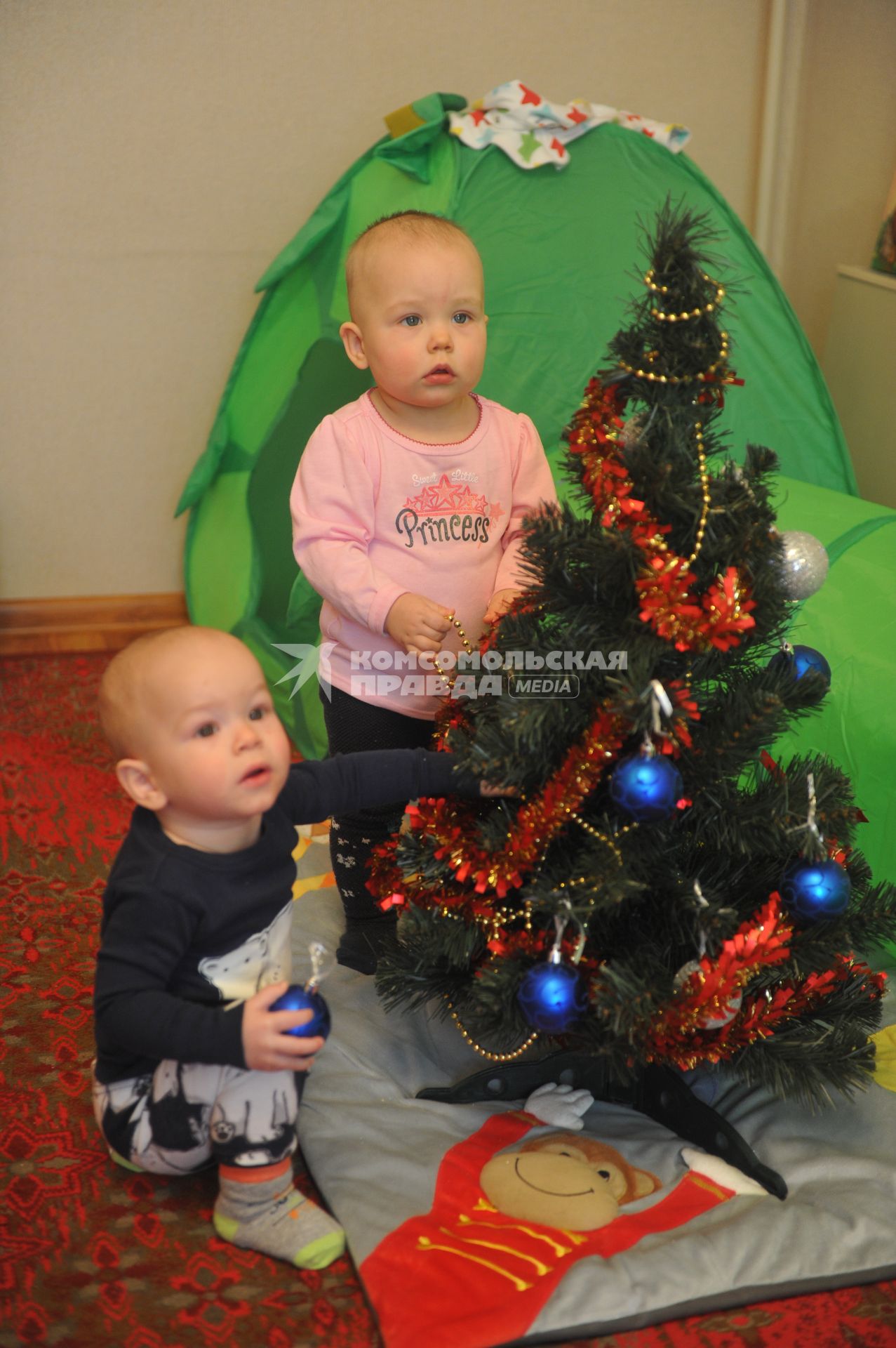 Малыши украшают новогоднюю елку.