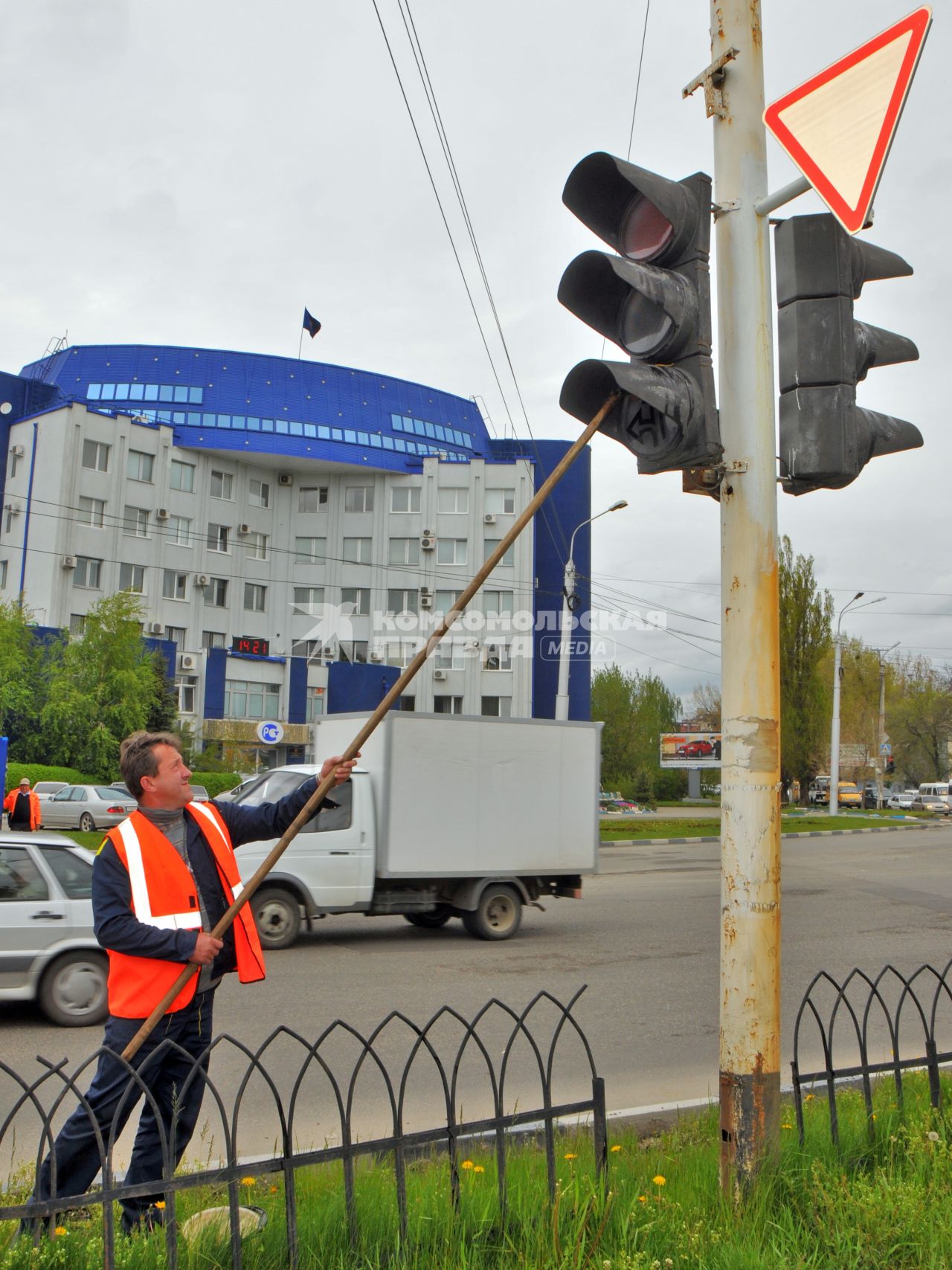 Мужчина моет светофор.