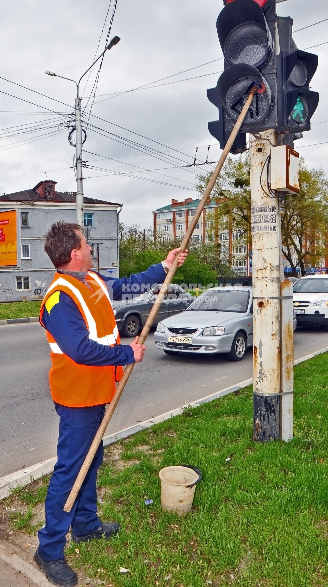 Мужчина моет светофор.