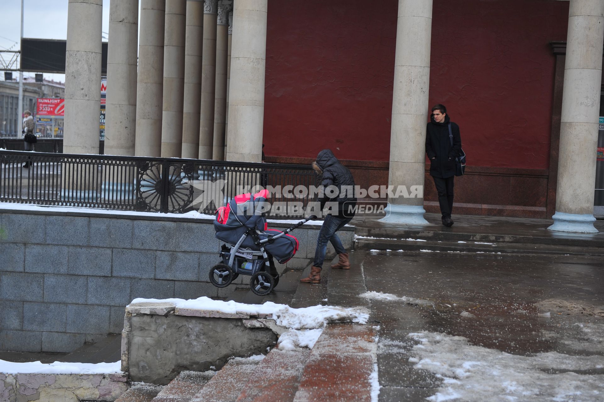 Здание станции метро `Динамо`. На снимке: девушка с детской коляской спускается по леснице.