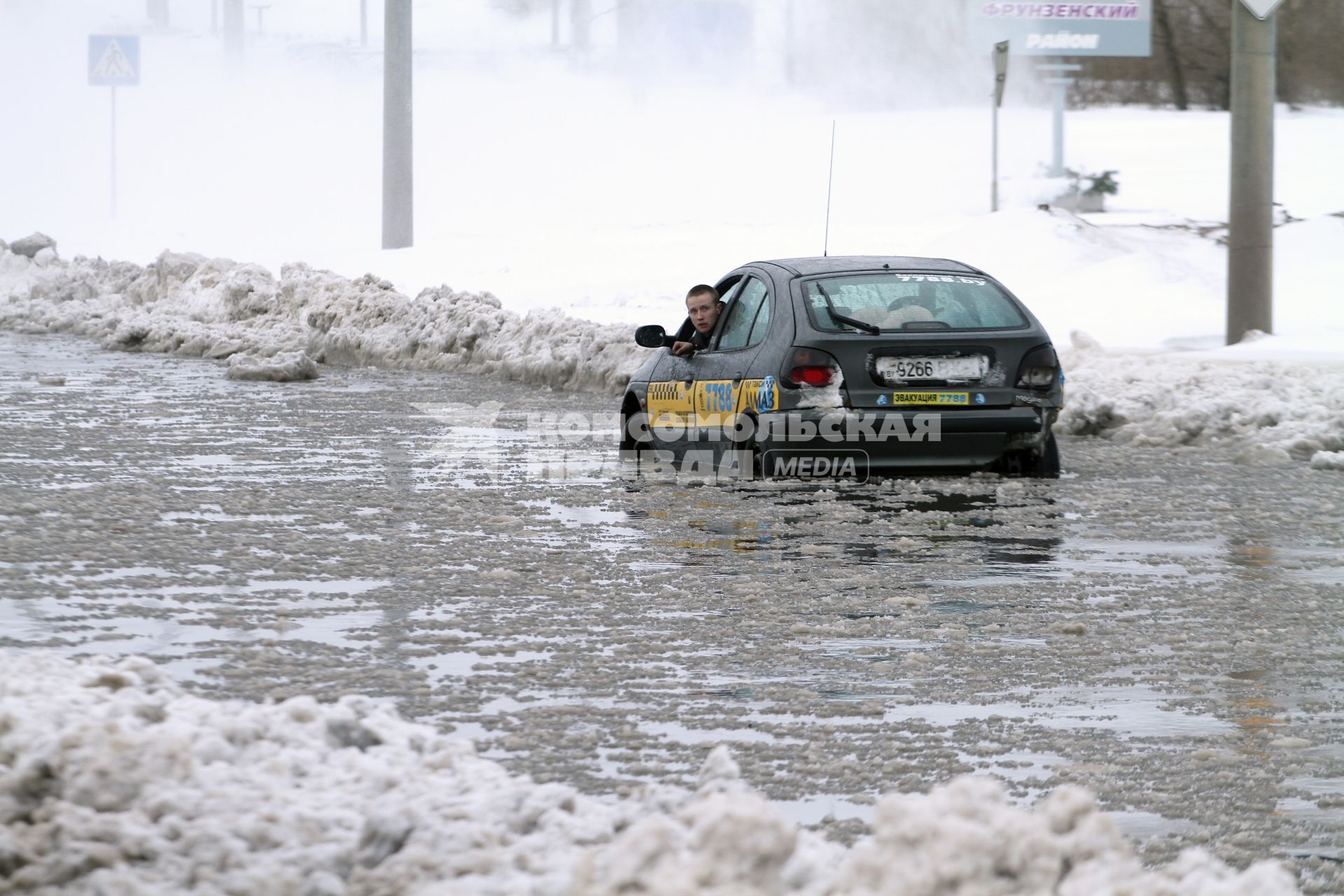 По затопленной улице Горецкого в Минске едет автомобиль.