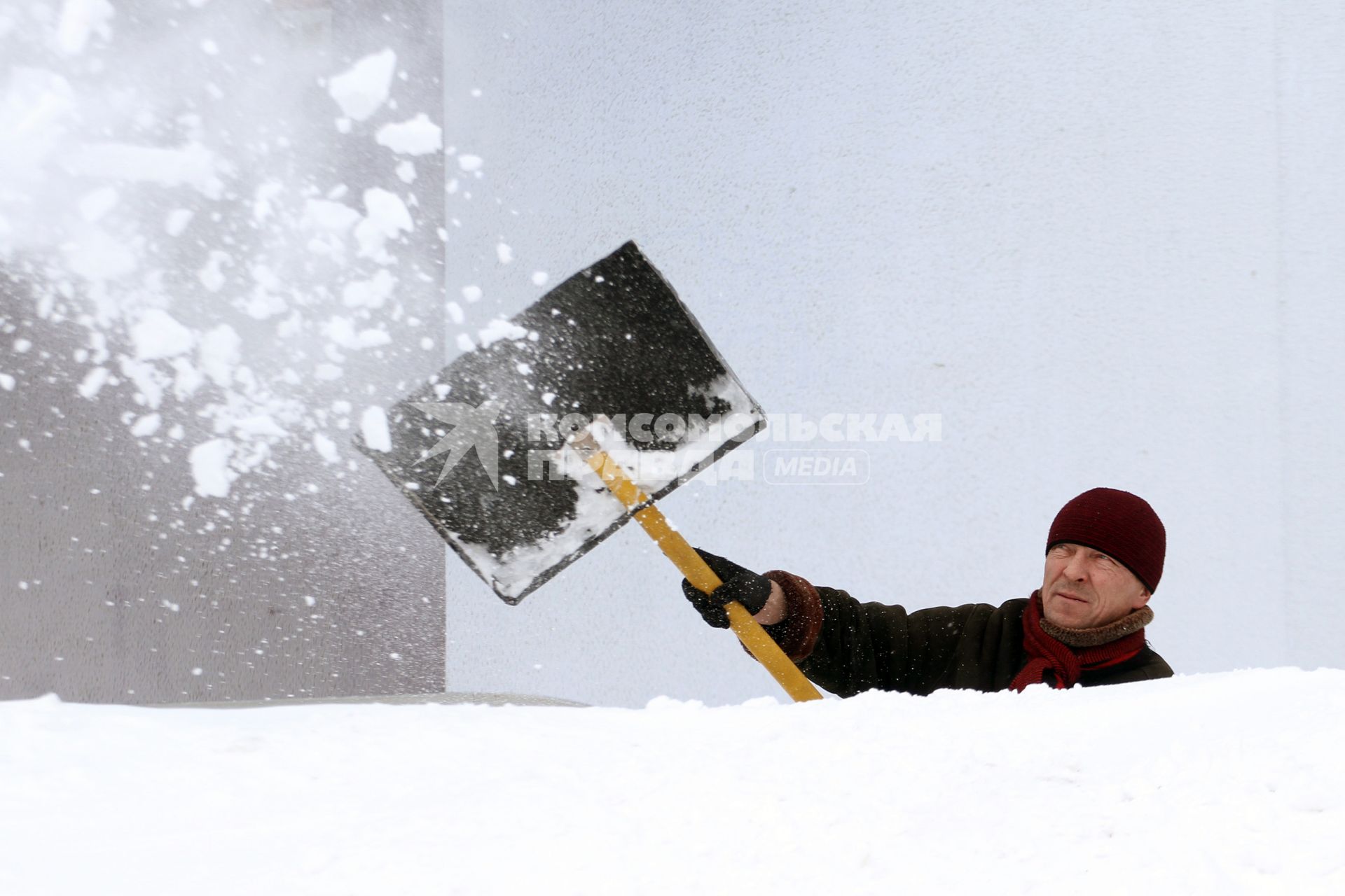Мужчина чистит улицу от снега.