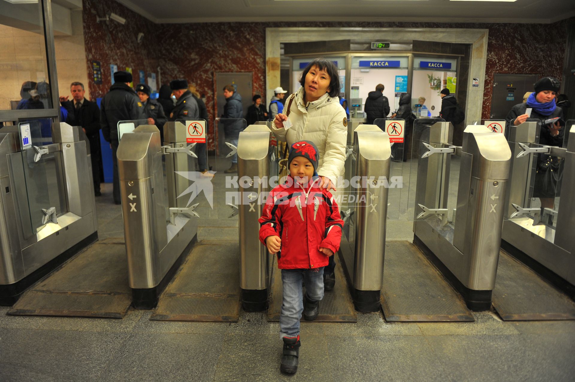 Московский метрополитен На снимке: пассажиры проходят в метро через турникет