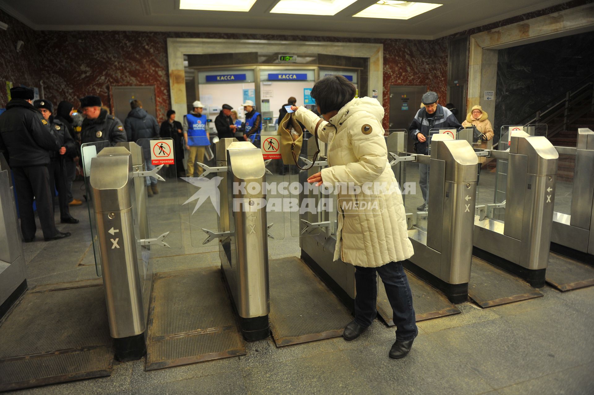 Московский метрополитен На снимке: пассажиры проходят в метро через турникет