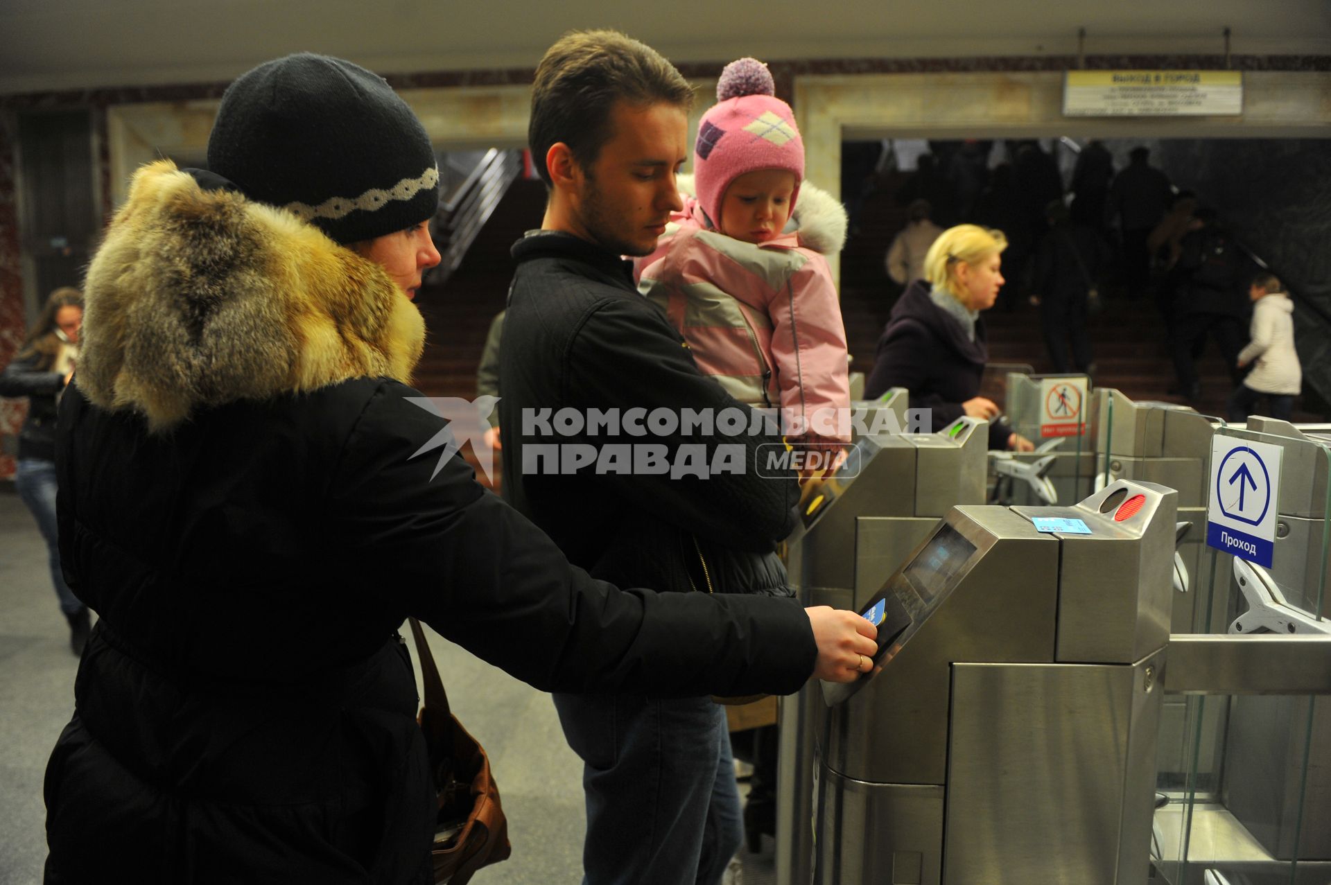 Московский метрополитен На снимке: пассажиры проходят в метро через турникет