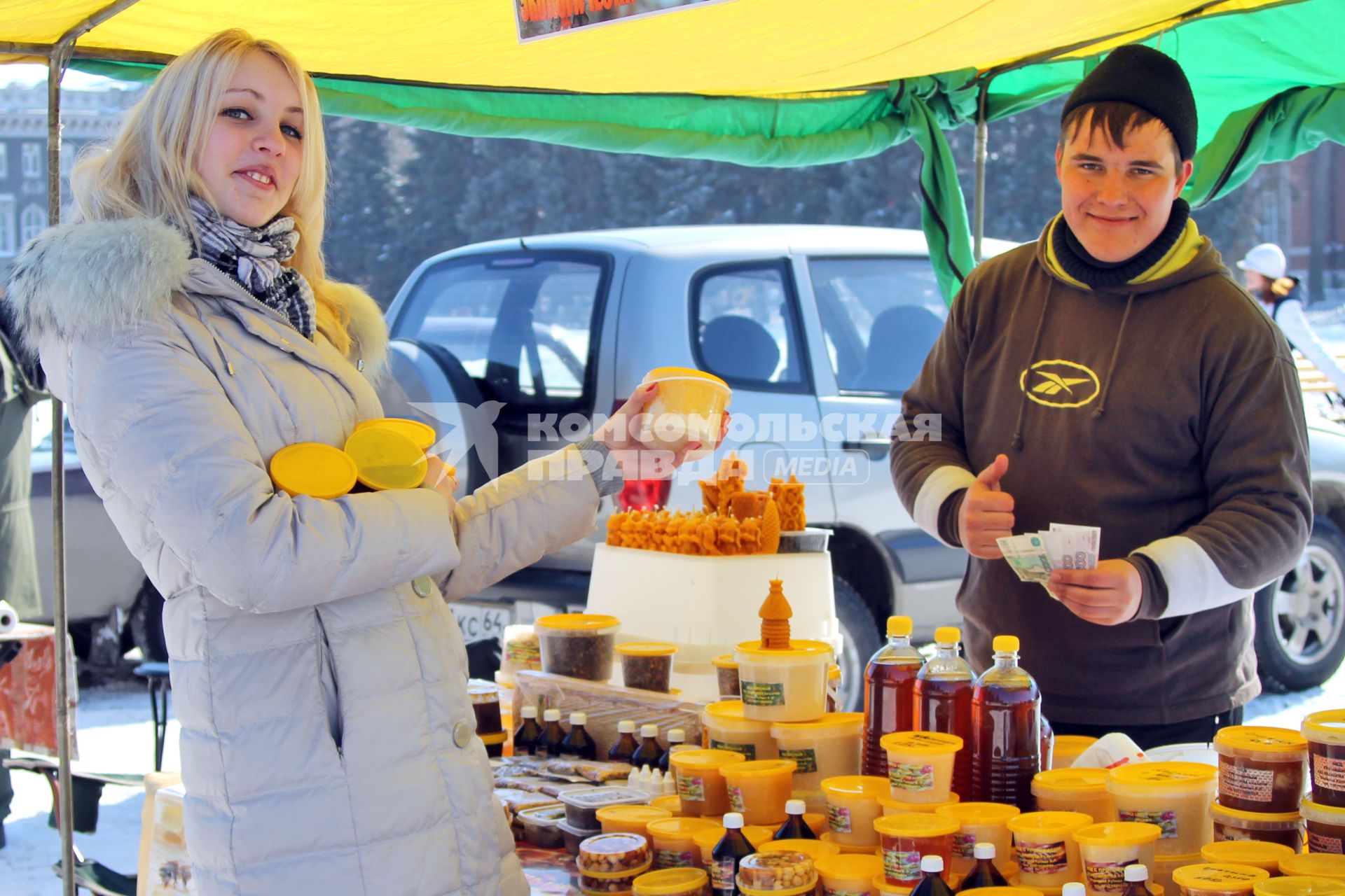 Ярмарка меда. На снимке: девушка покупает мед.