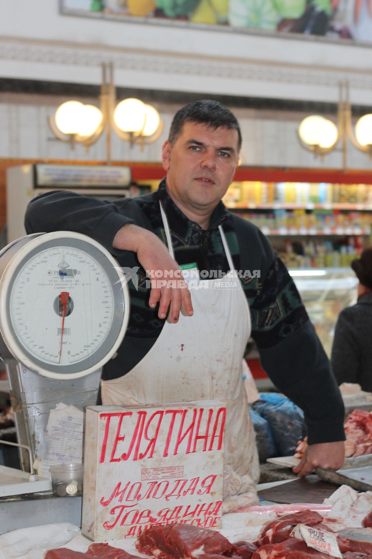 Мясной ряд продуктового рынка. Продавец за прилавком.