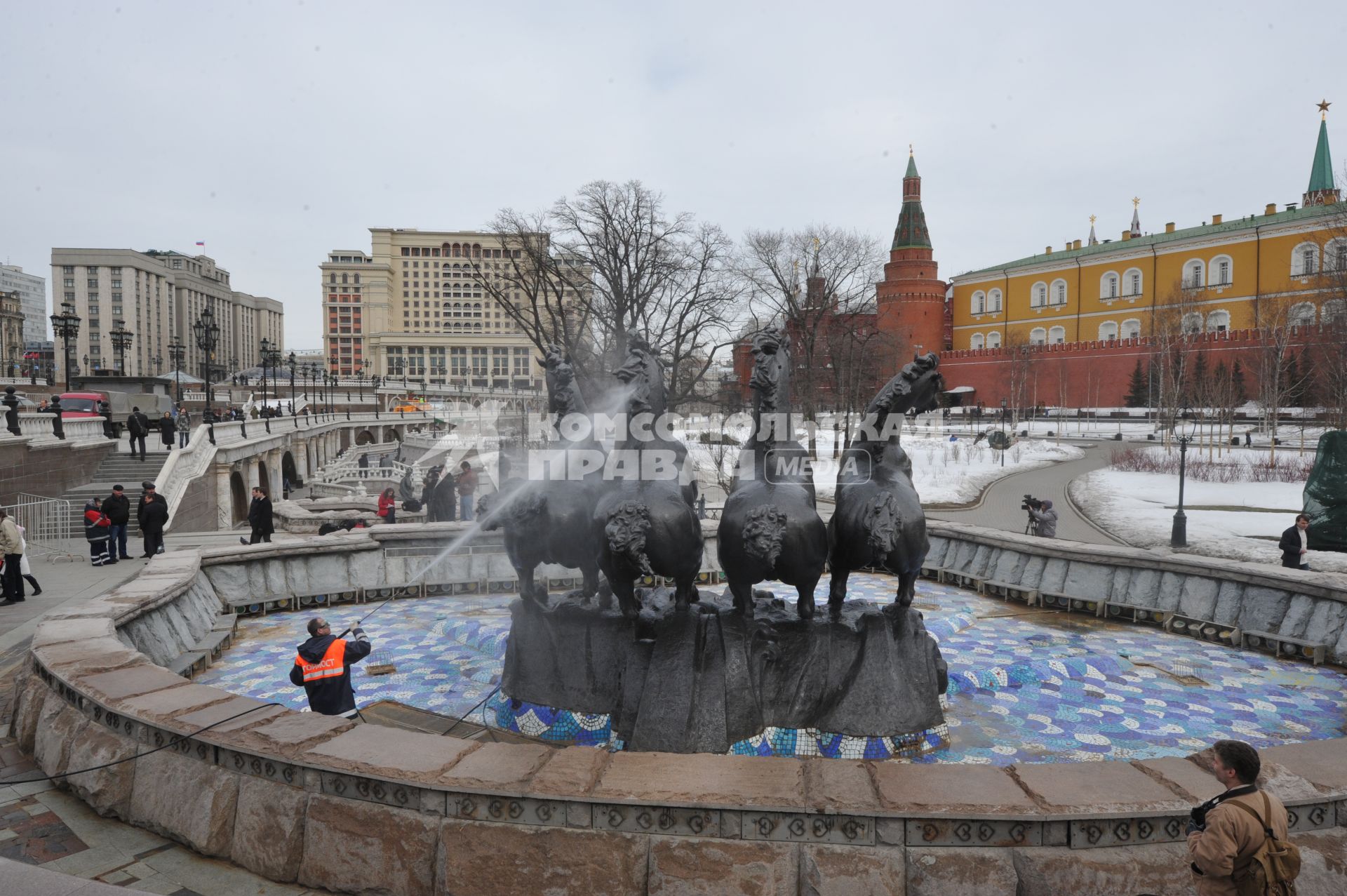 Манежная площадь. На снимке: сотрудник коммунальной службы города моет скульптурную группу `Времена года` фонтана \"Гейзер`.