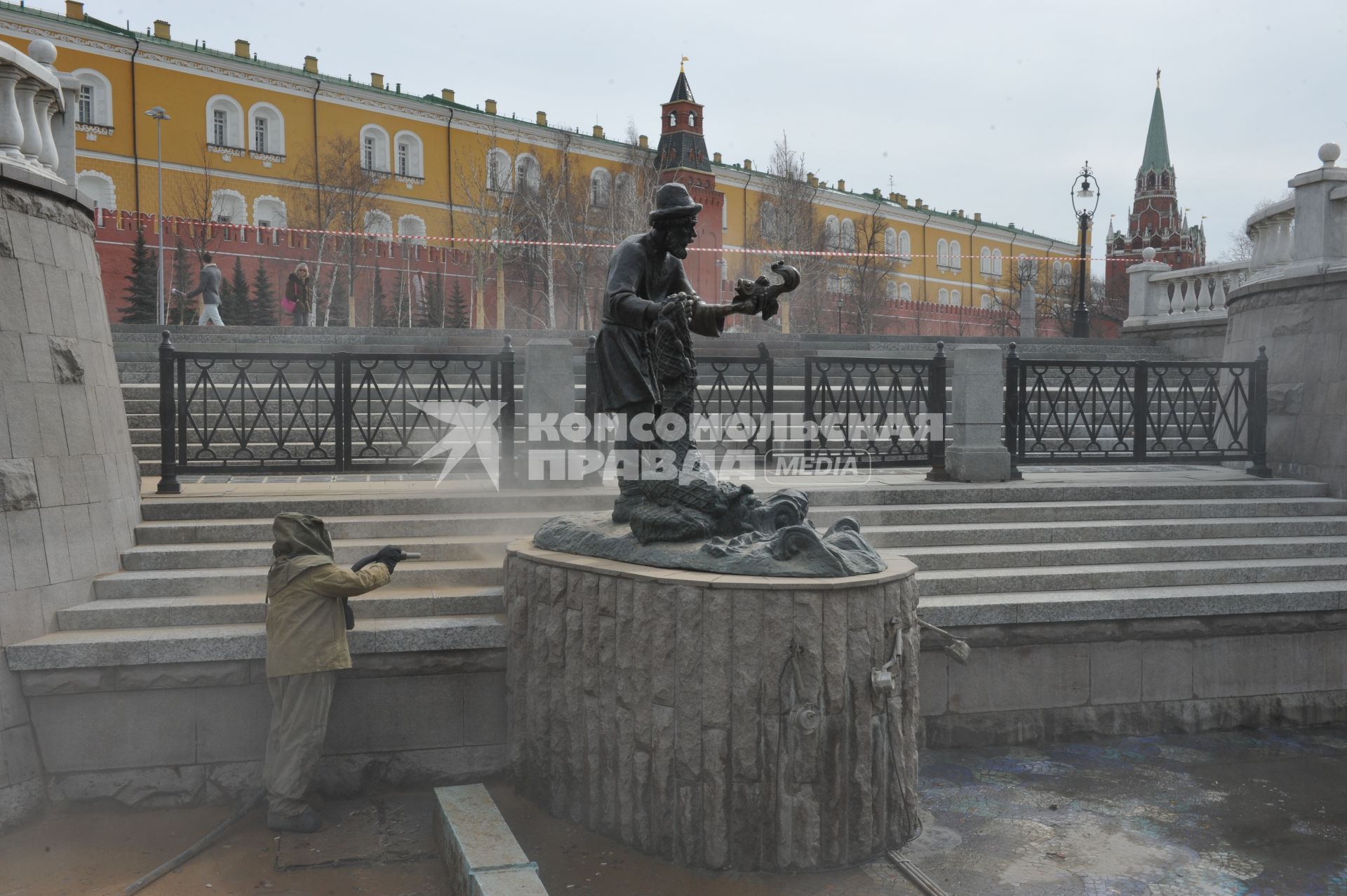 Манежная площадь. На снимке: сотрудник коммунальной службы города моет скульптуру по мотивам сказки `О рыбаке и рыбке`.