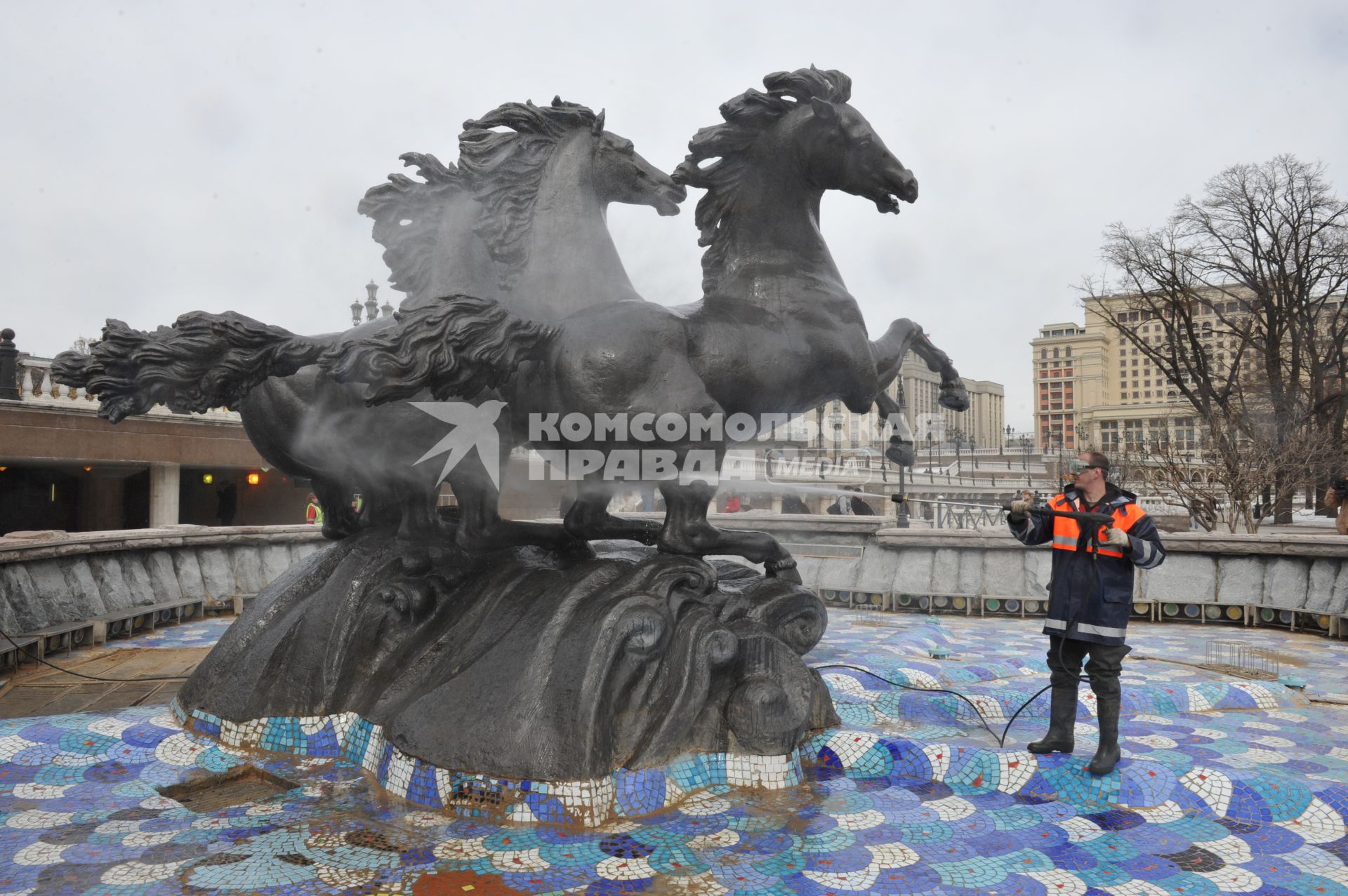 Манежная площадь. На снимке: сотрудник коммунальной службы города моет скульптурную группу `Времена года` фонтана \"Гейзер`.