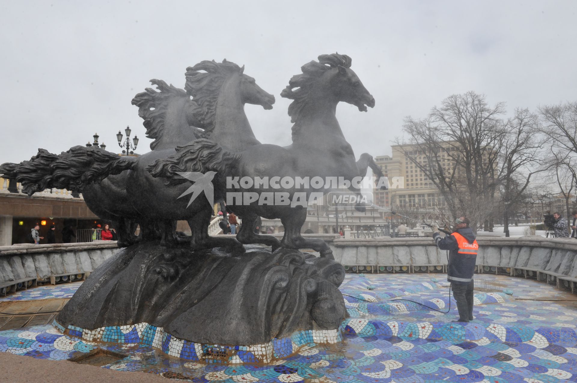 Манежная площадь. На снимке: сотрудник коммунальной службы города моет скульптурную группу `Времена года` фонтана \"Гейзер`.