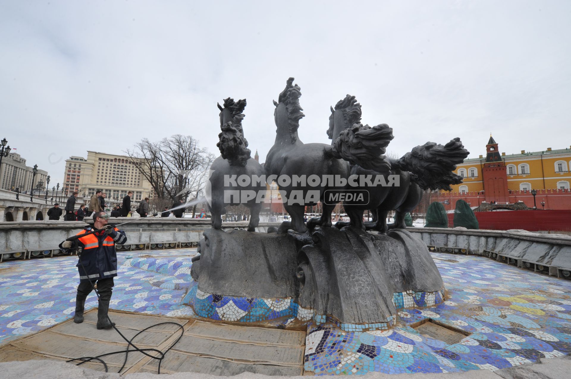 Манежная площадь. На снимке: сотрудник коммунальной службы города моет скульптурную группу `Времена года` фонтана \"Гейзер`.