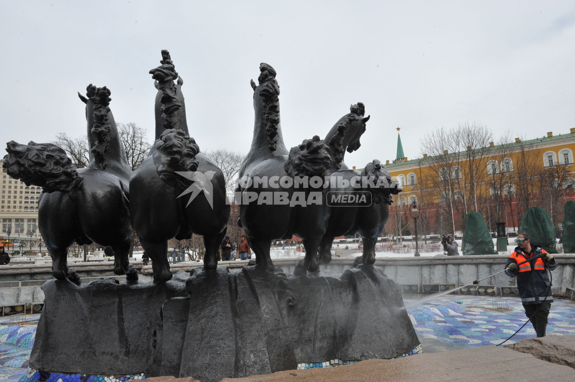 Манежная площадь. На снимке: сотрудник коммунальной службы города моет скульптурную группу `Времена года` фонтана \"Гейзер`.