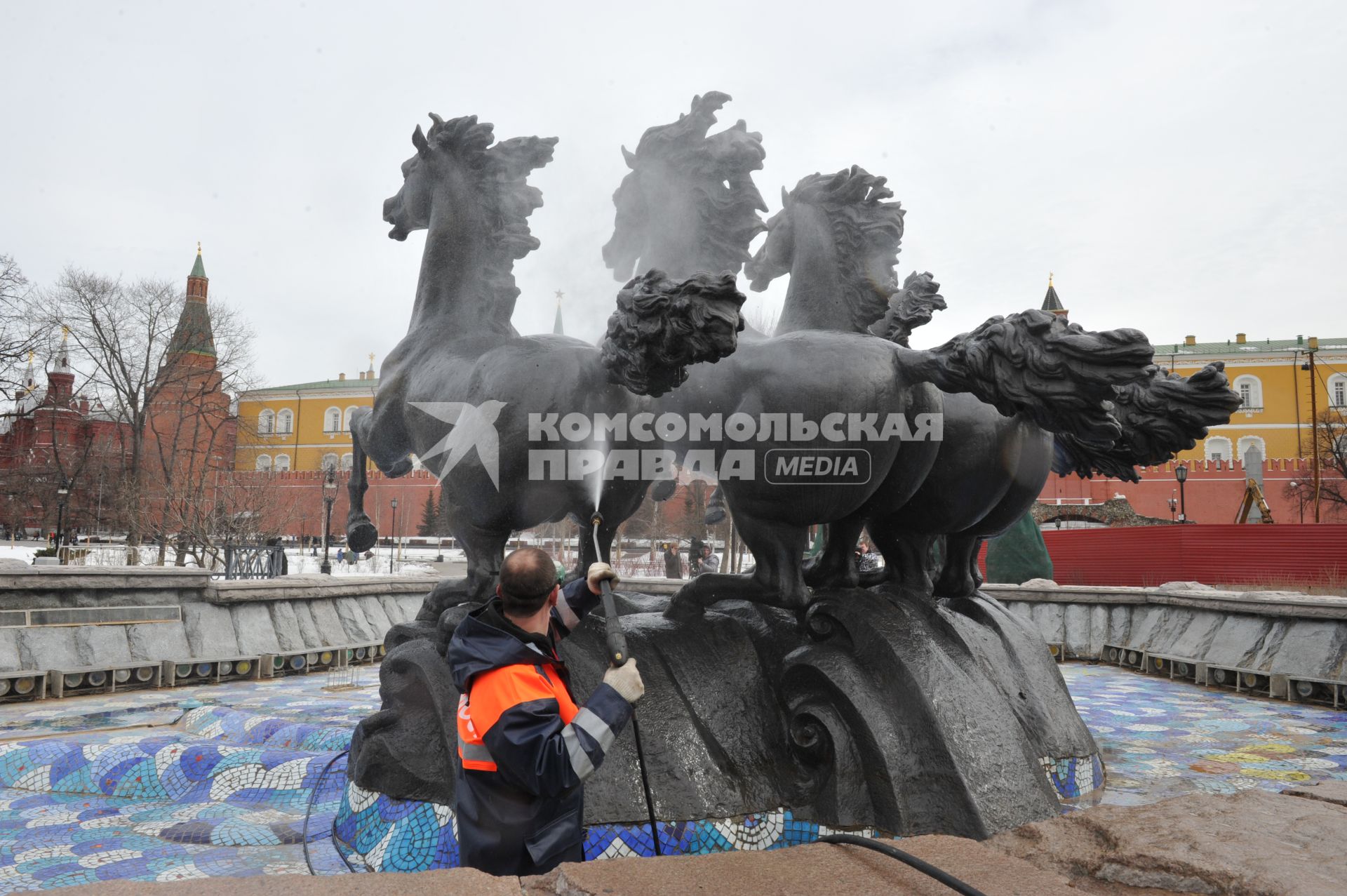 Манежная площадь. На снимке: сотрудник коммунальной службы города моет скульптурную группу `Времена года` фонтана \"Гейзер`.