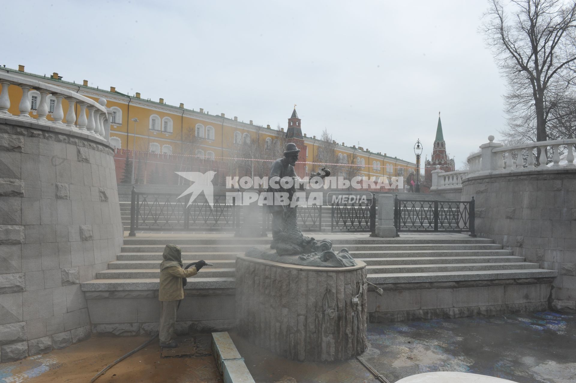 Манежная площадь. На снимке: сотрудник коммунальной службы города моет скульптуру по мотивам сказки `О рыбаке и рыбке`.