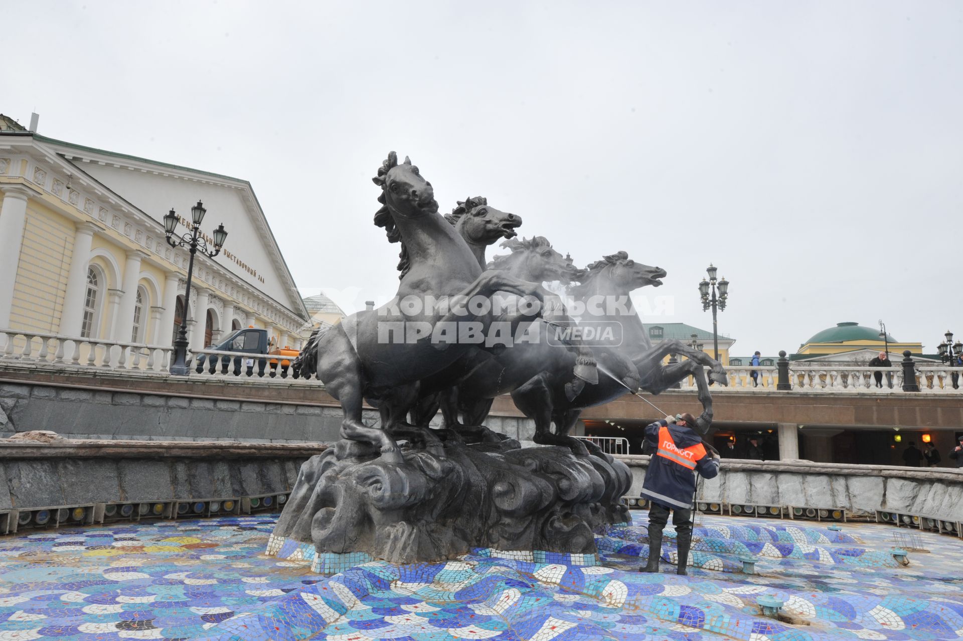 Манежная площадь. На снимке: сотрудник коммунальной службы города моет скульптурную группу `Времена года` фонтана \"Гейзер`.