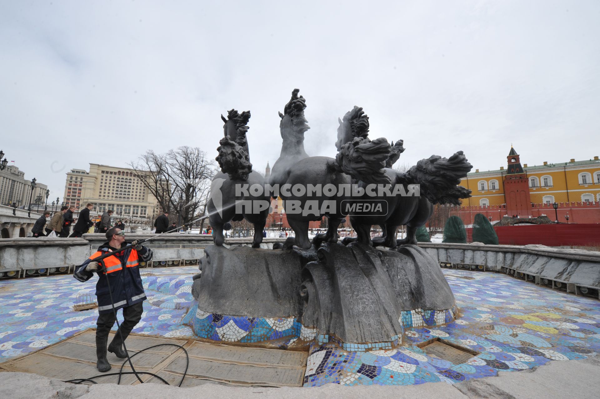 Манежная площадь. На снимке: сотрудник коммунальной службы города моет скульптурную группу `Времена года` фонтана \"Гейзер`.