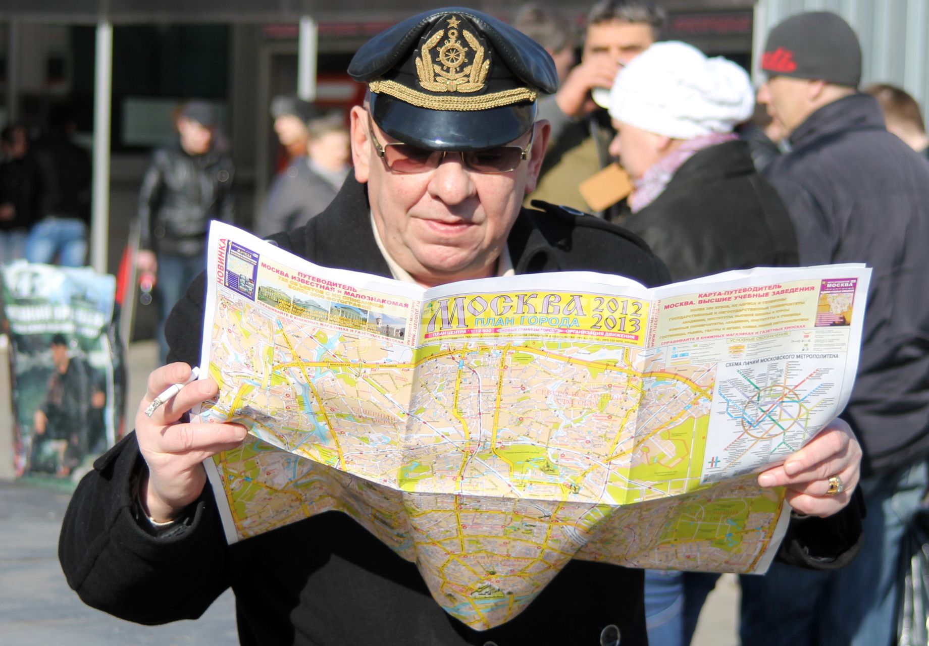 Человек в капитанской фуражке изучает карту Москвы.