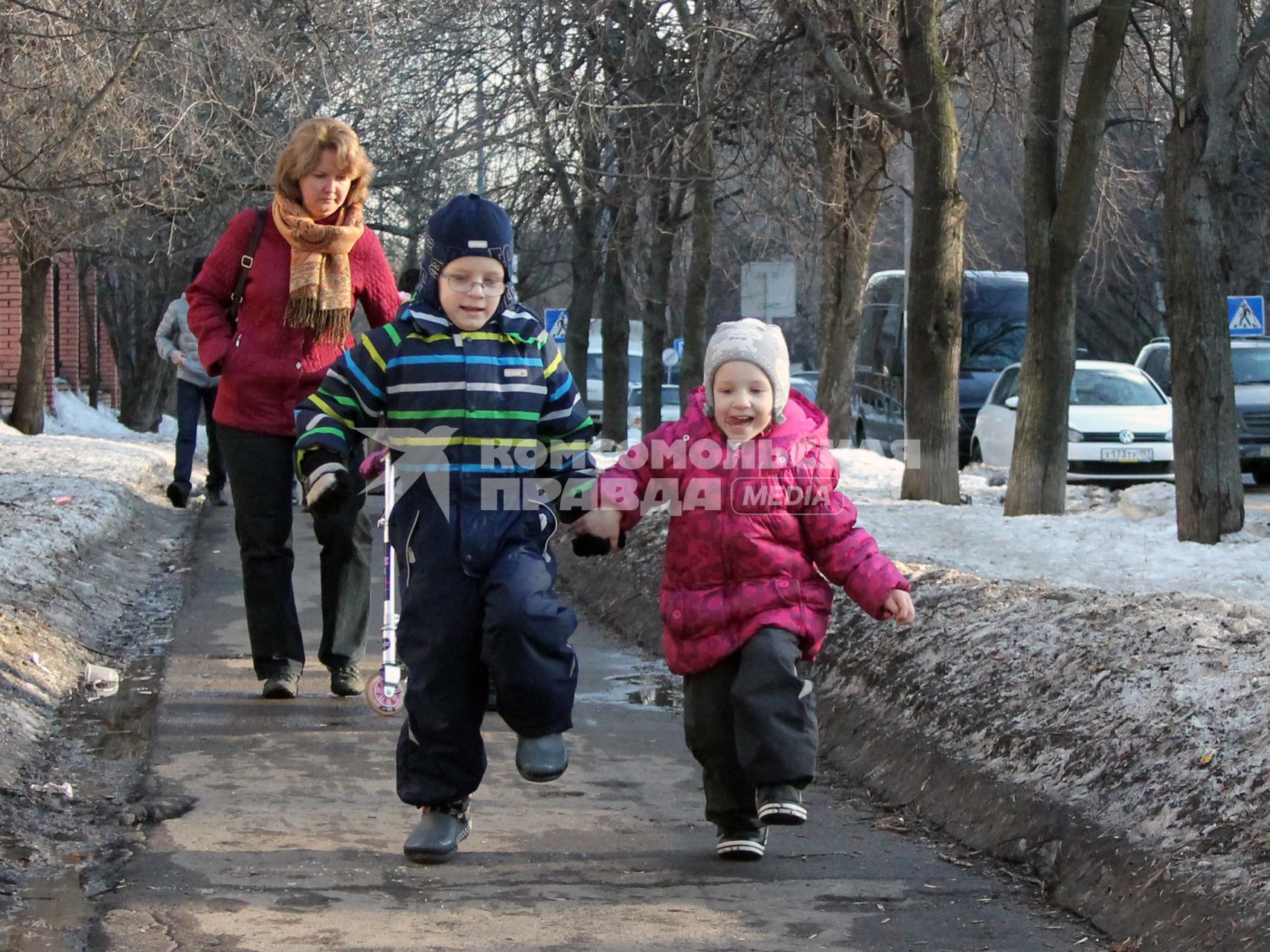 Двое детей гуляют по улице.