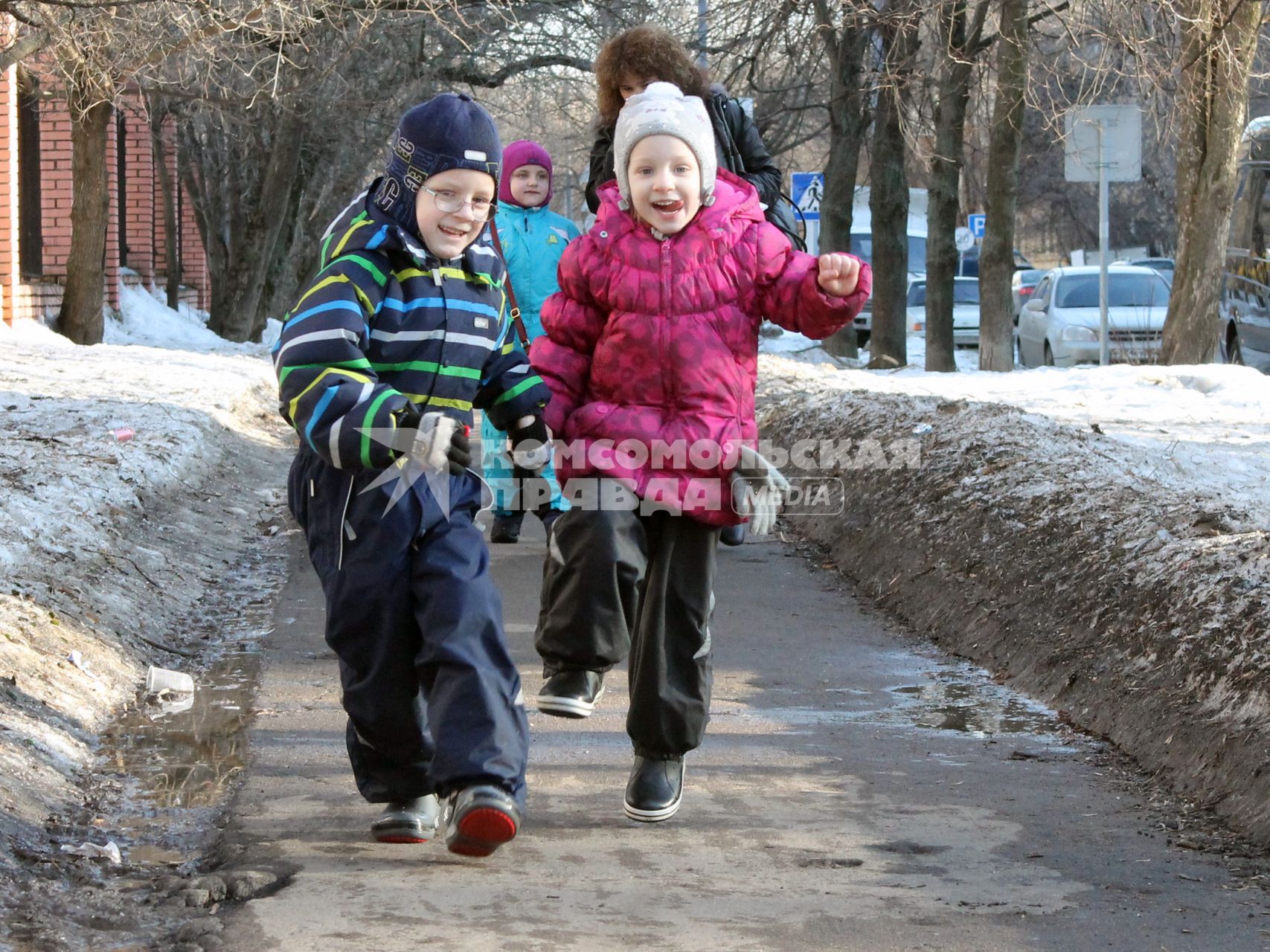 Двое детей гуляют по улице.