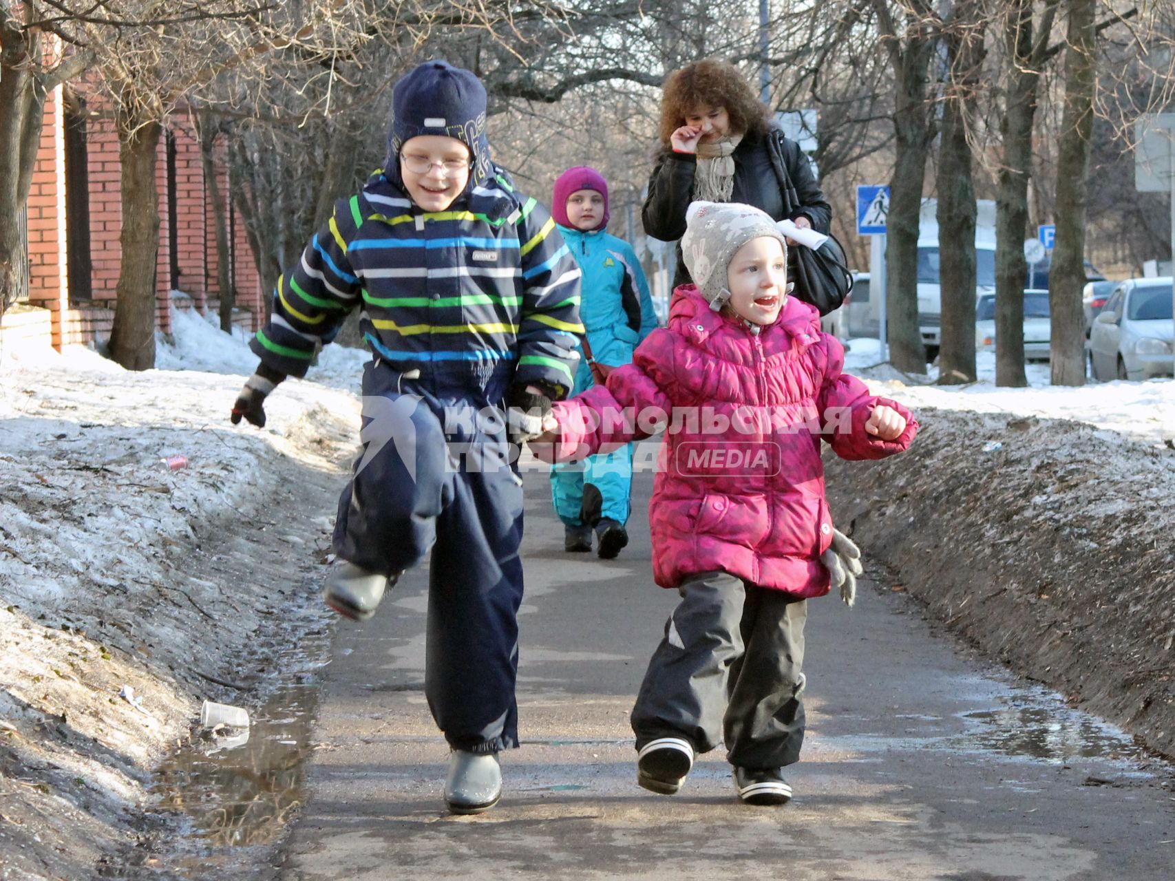 Двое детей гуляют по улице.