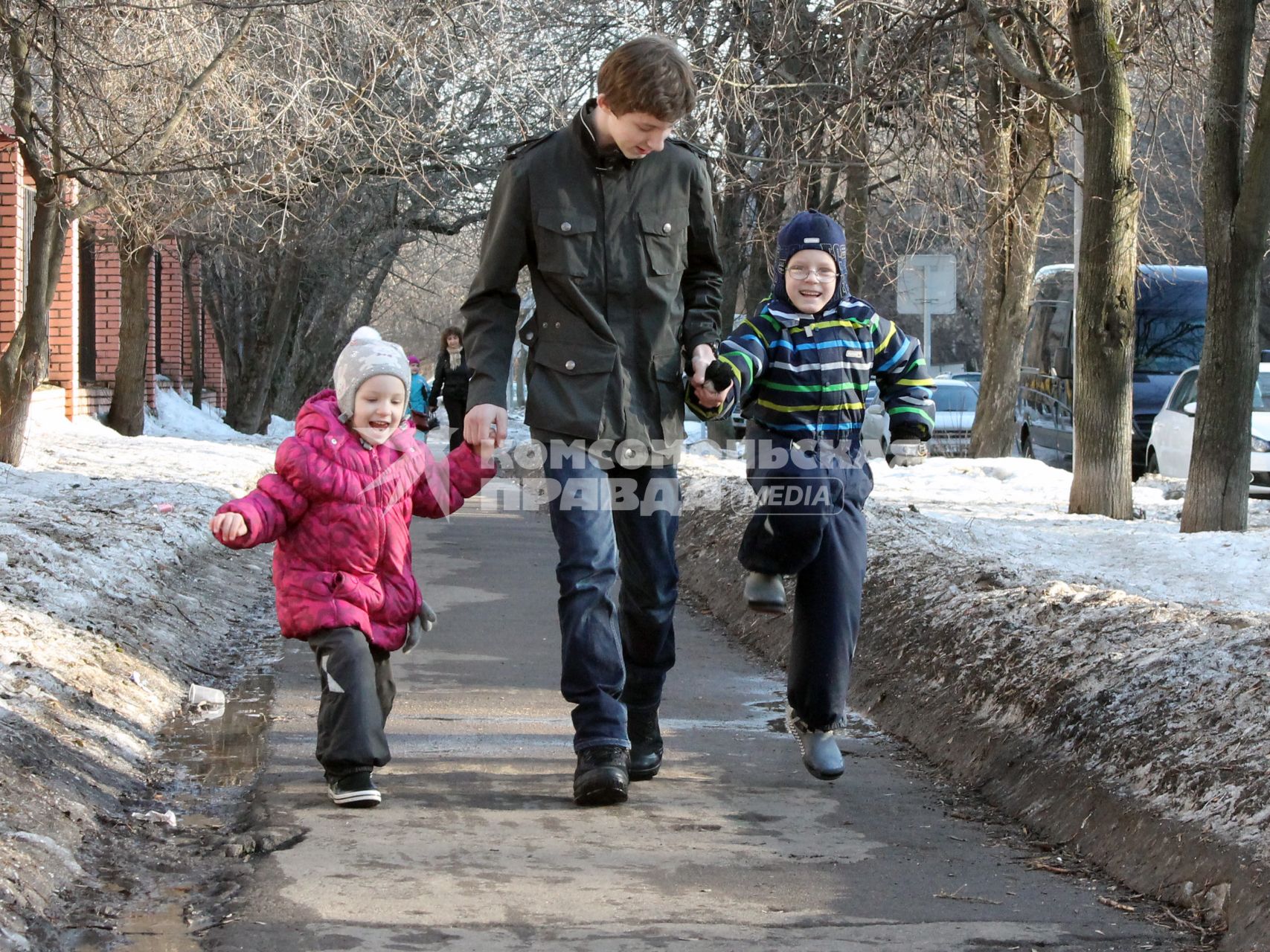 Двое детей гуляют по улице.
