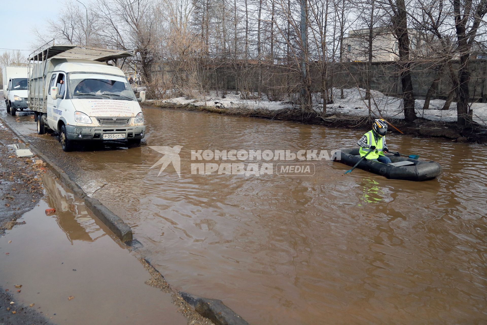 Из-за быстрого таяния снегов весенние паводковые воды затопили проезжую часть на улицах. На снимке: мужчина на резиновой лодке на затопленной улице.