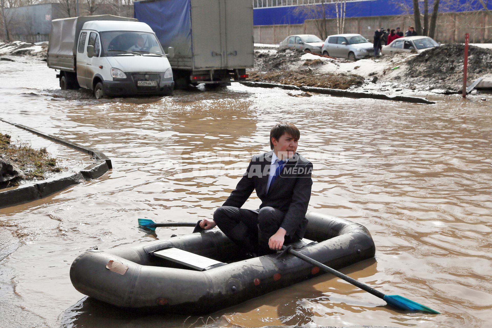 Из-за быстрого таяния снегов весенние паводковые воды затопили проезжую часть на улицах. На снимке: мужчина на резиновой лодке на затопленной улице.