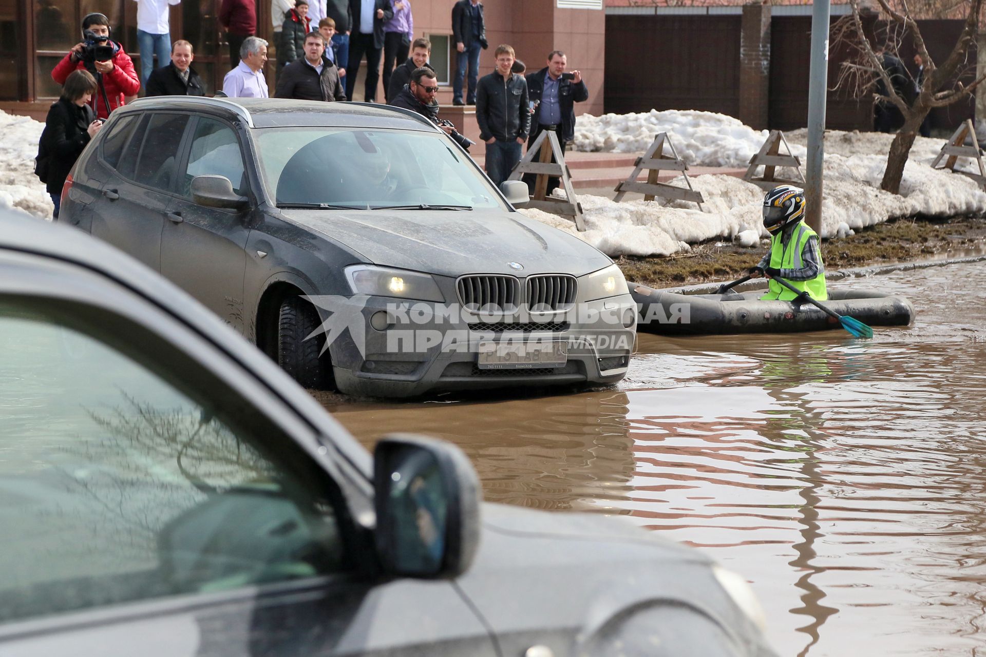 Из-за быстрого таяния снегов весенние паводковые воды затопили проезжую часть на улицах. На снимке: мужчина на резиновой лодке на затопленной улице.