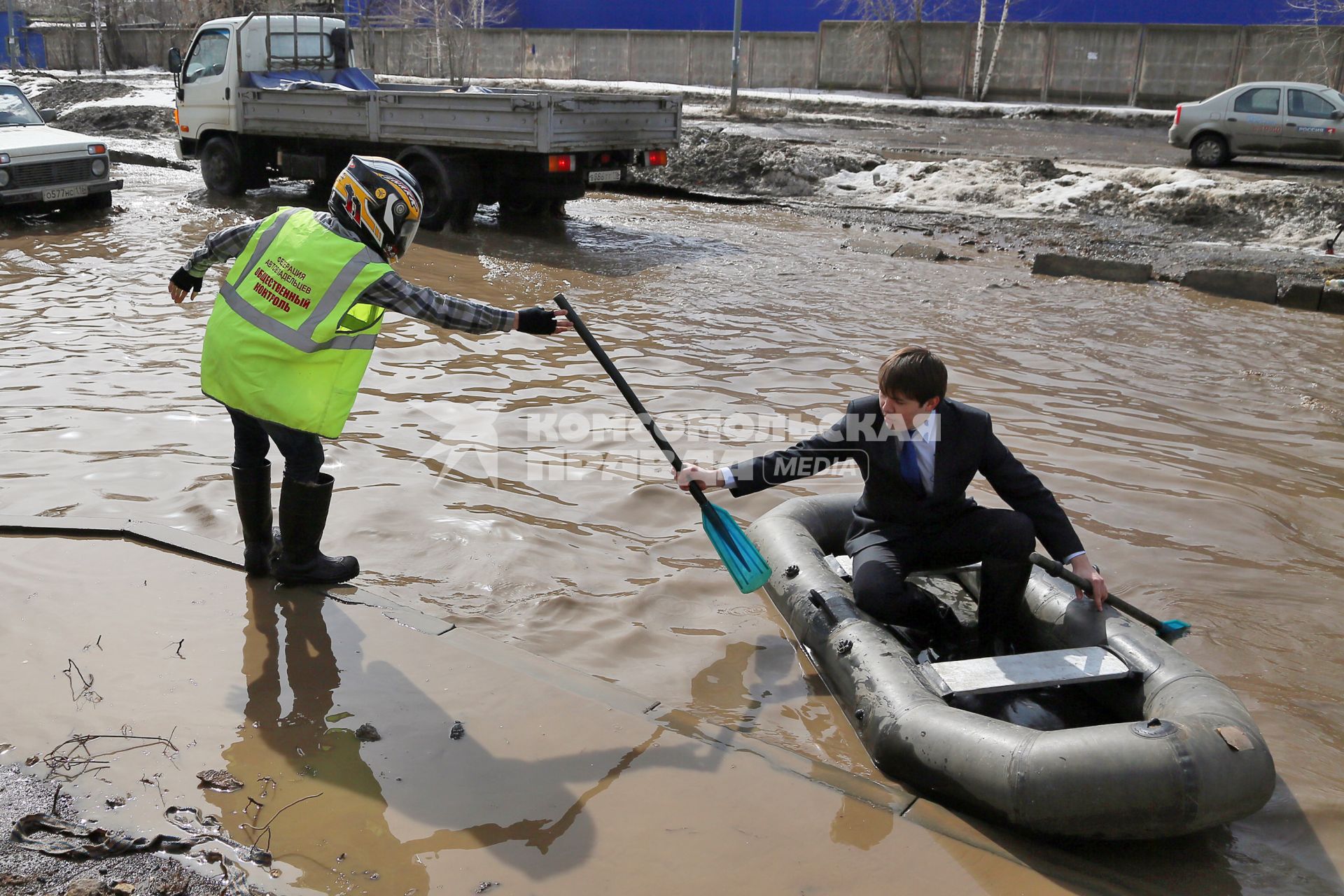 Из-за быстрого таяния снегов весенние паводковые воды затопили проезжую часть на улицах. На снимке: мужчины на резиновой лодке на затопленной улице.