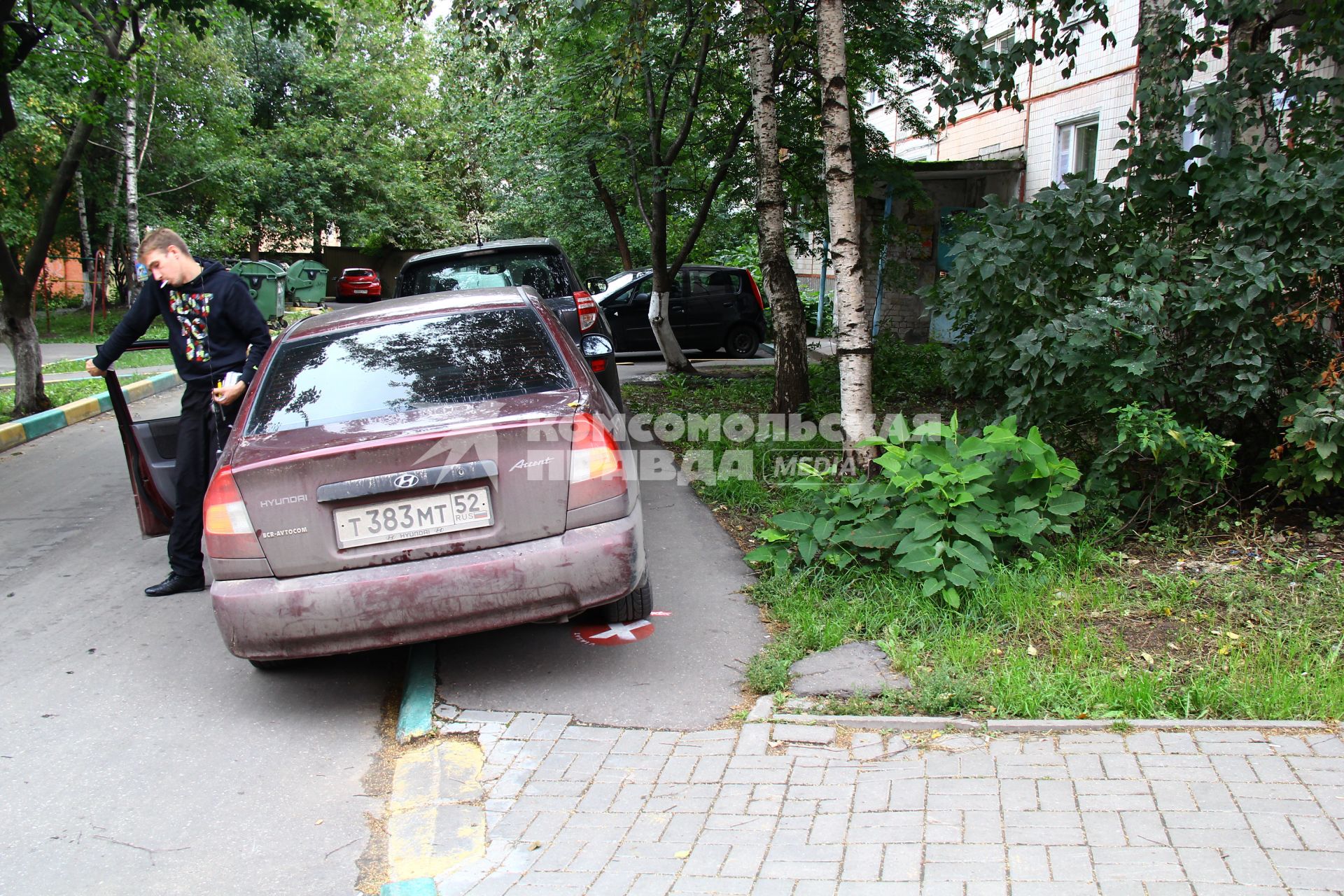 Мужчина припарковал свой автомобиль на тротуаре.