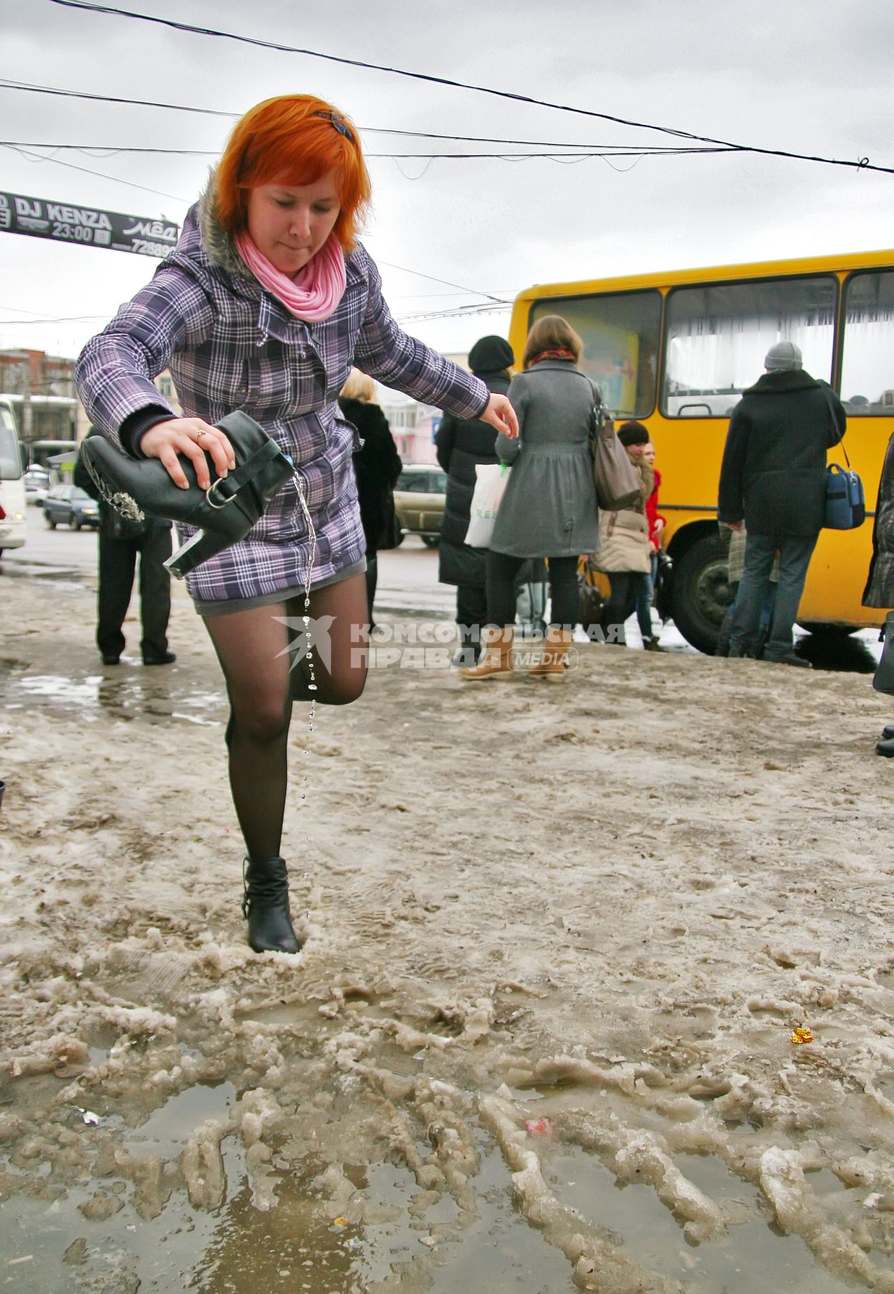 Девушка выливает из сапога воду.