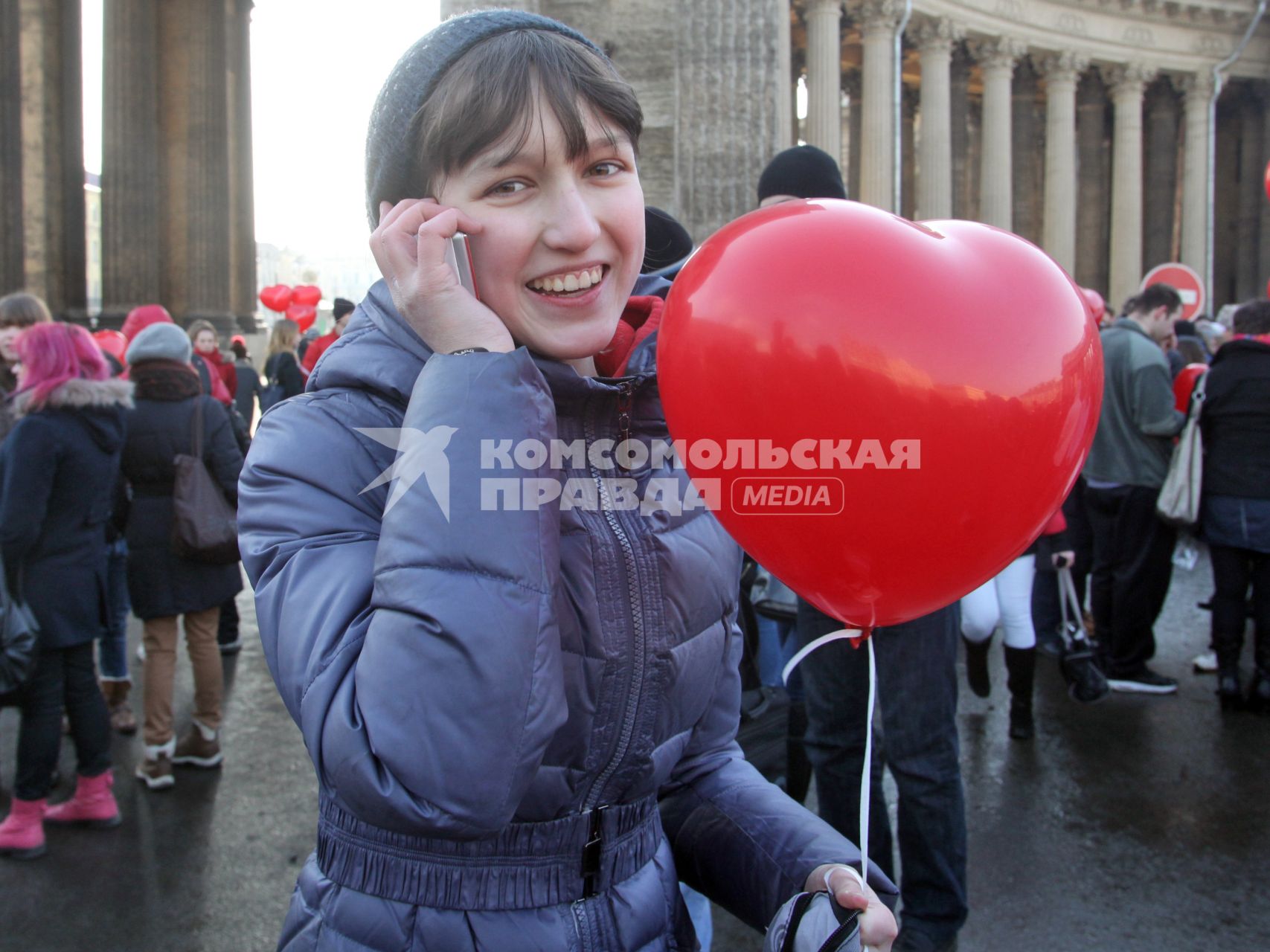 Акция в Санкт-Петербурге `Сердце города 2012` На снимке: девушка разговаривает по мобильному телефону, держит в руке надувной шарик в форме сердца.