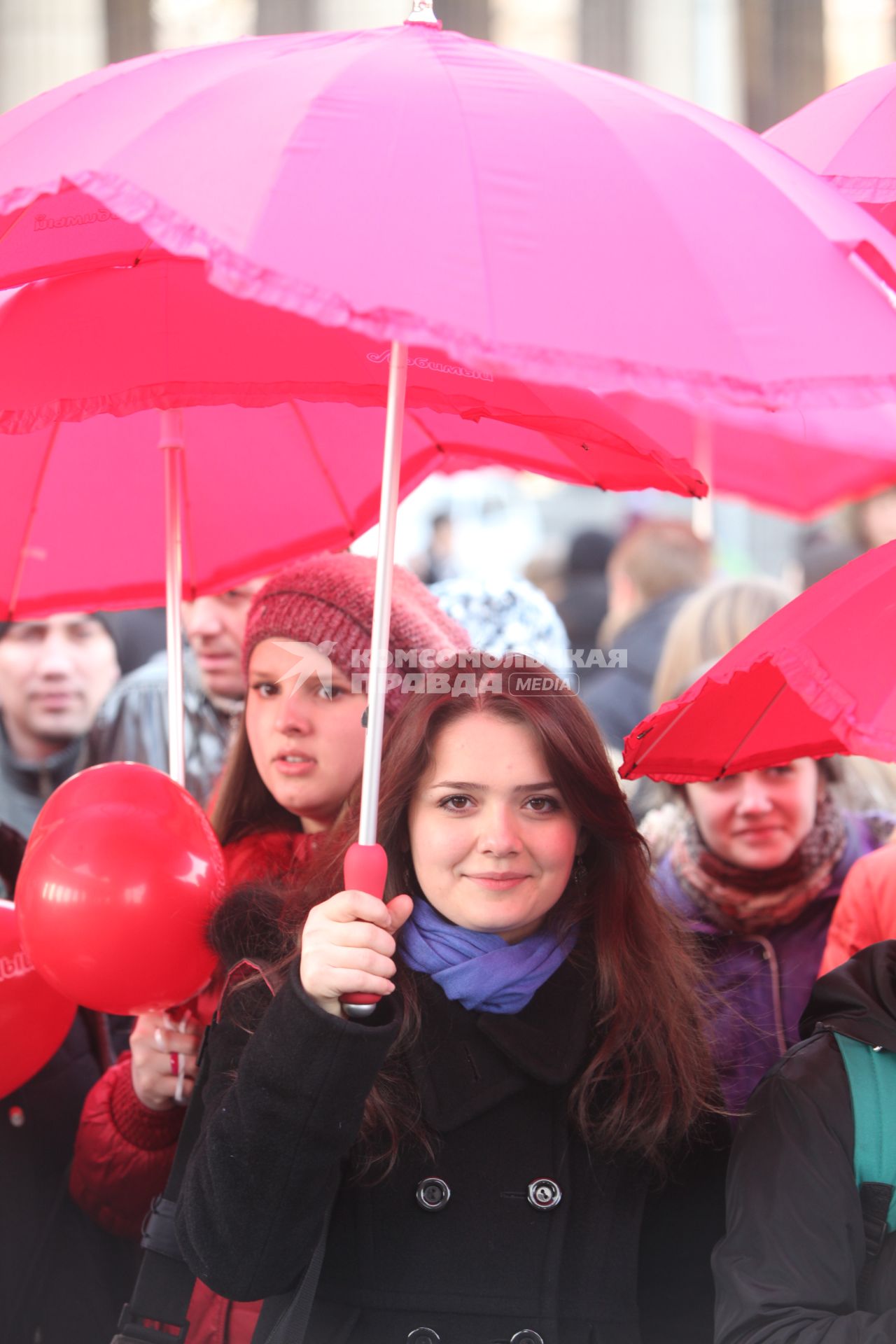 Акция в Санкт-Петербурге `Сердце города 2012` На снимке: девушка стоит под красным зонтом.
