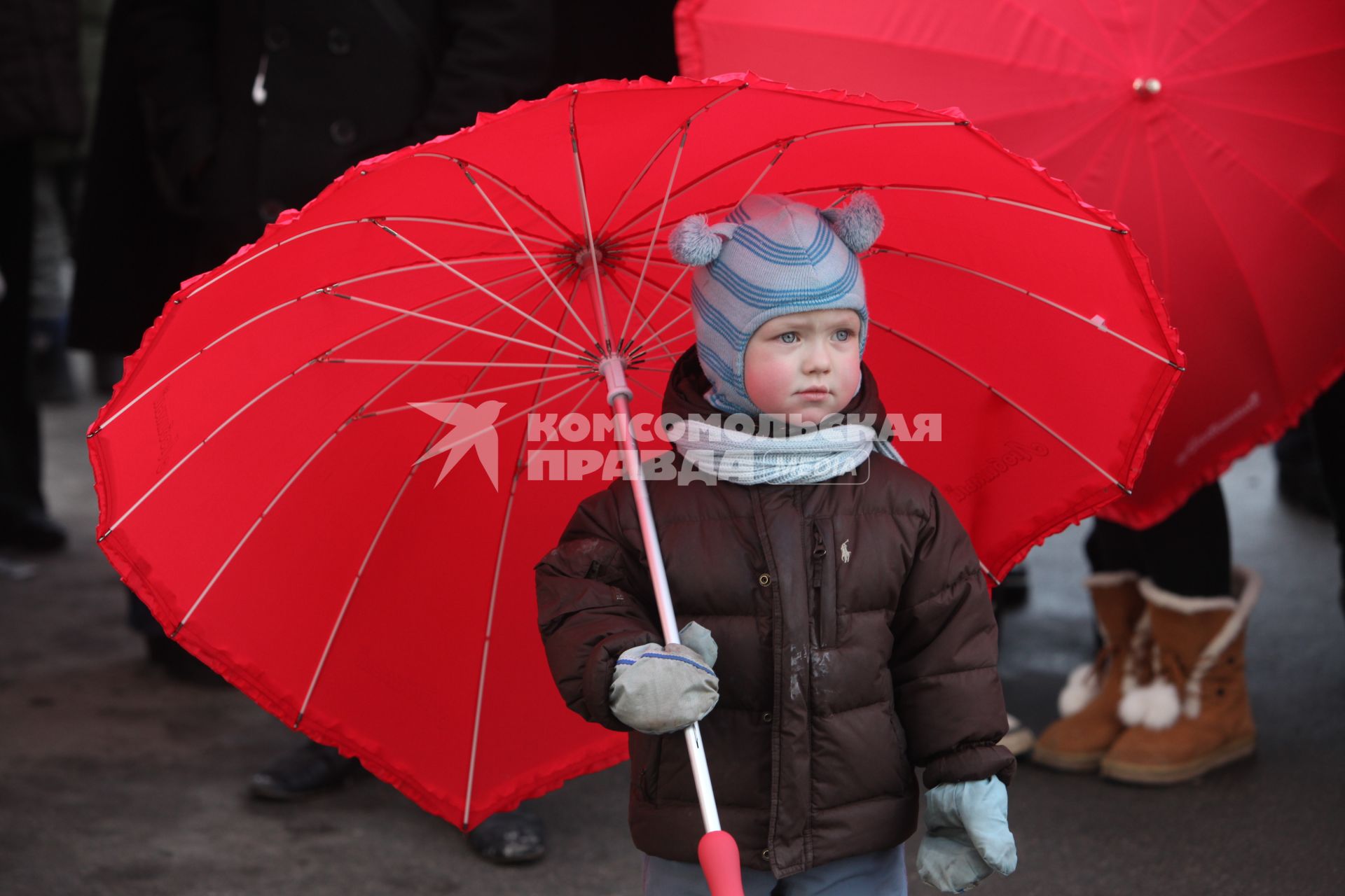 Акция в Санкт-Петербурге `Сердце города 2012` На снимке: ребенок под красным зонтом.