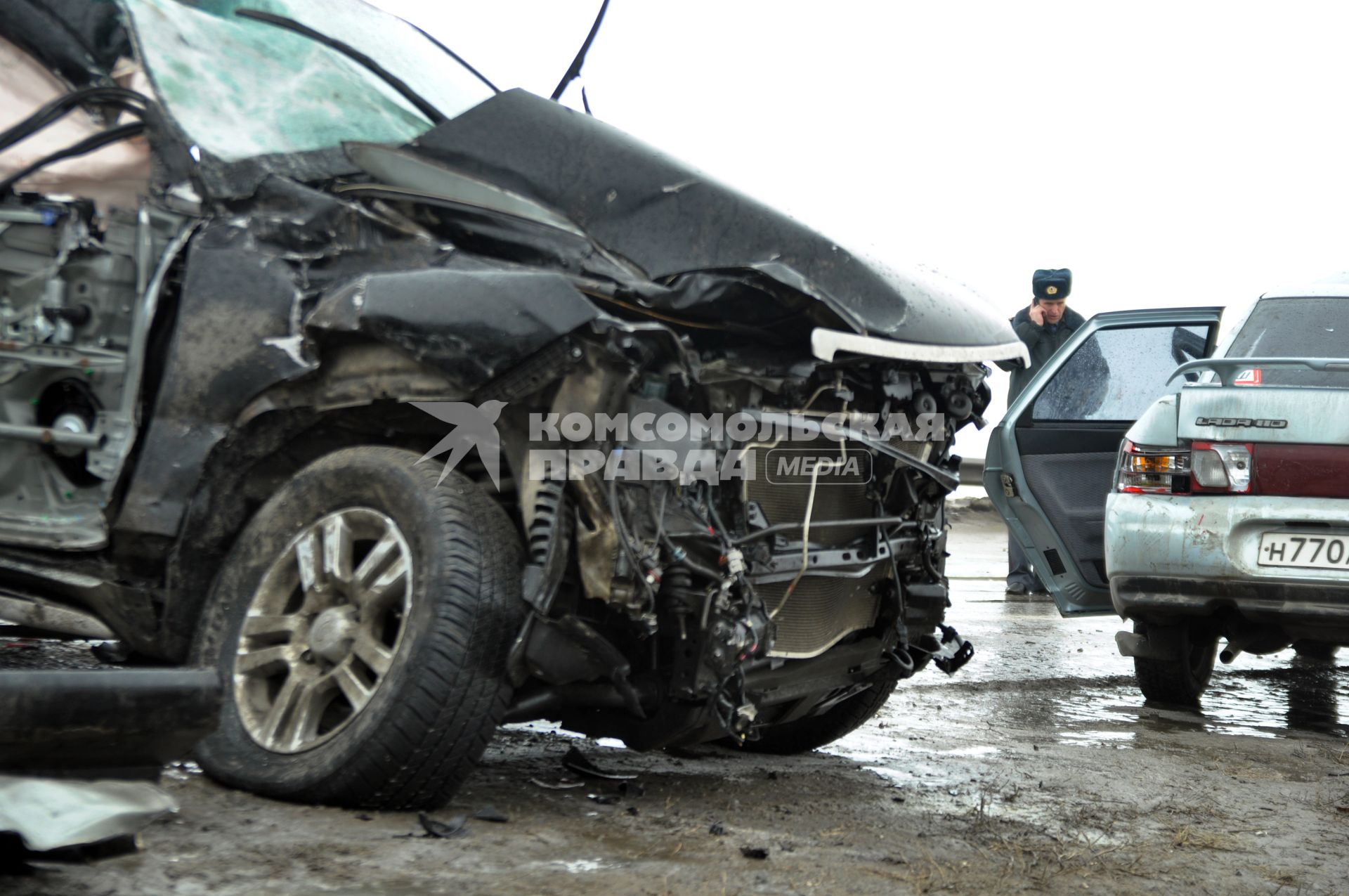 Покореженный автомобиль на загородной трассе.