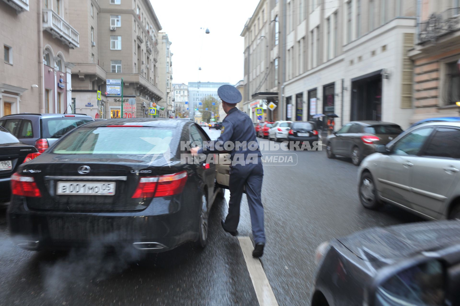 `Дагестанская свадьба в центре Москвы: разгоряченные джигиты стреляли в воздух и другие машины`. На снимке: одна из гостей свадьбы, игнорируя полицейского, скрывается.