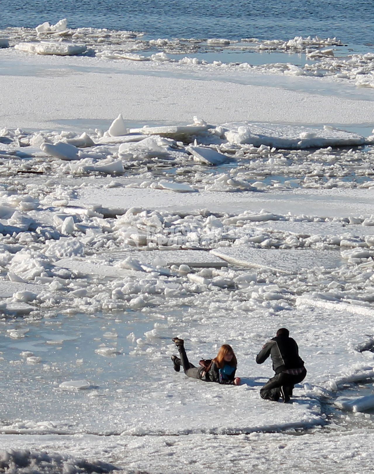 Начало ледохода на Волге. Девушка позирует фотографу лежа на льдине.